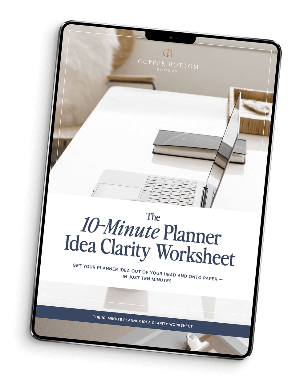 Digital device displaying a worksheet titled 'The 10-Minute Planner Idea Clarity Worksheet' from Copper Bottom Design Co, with a minimalistic workspace featuring a laptop, notebooks, and a decorative tray.