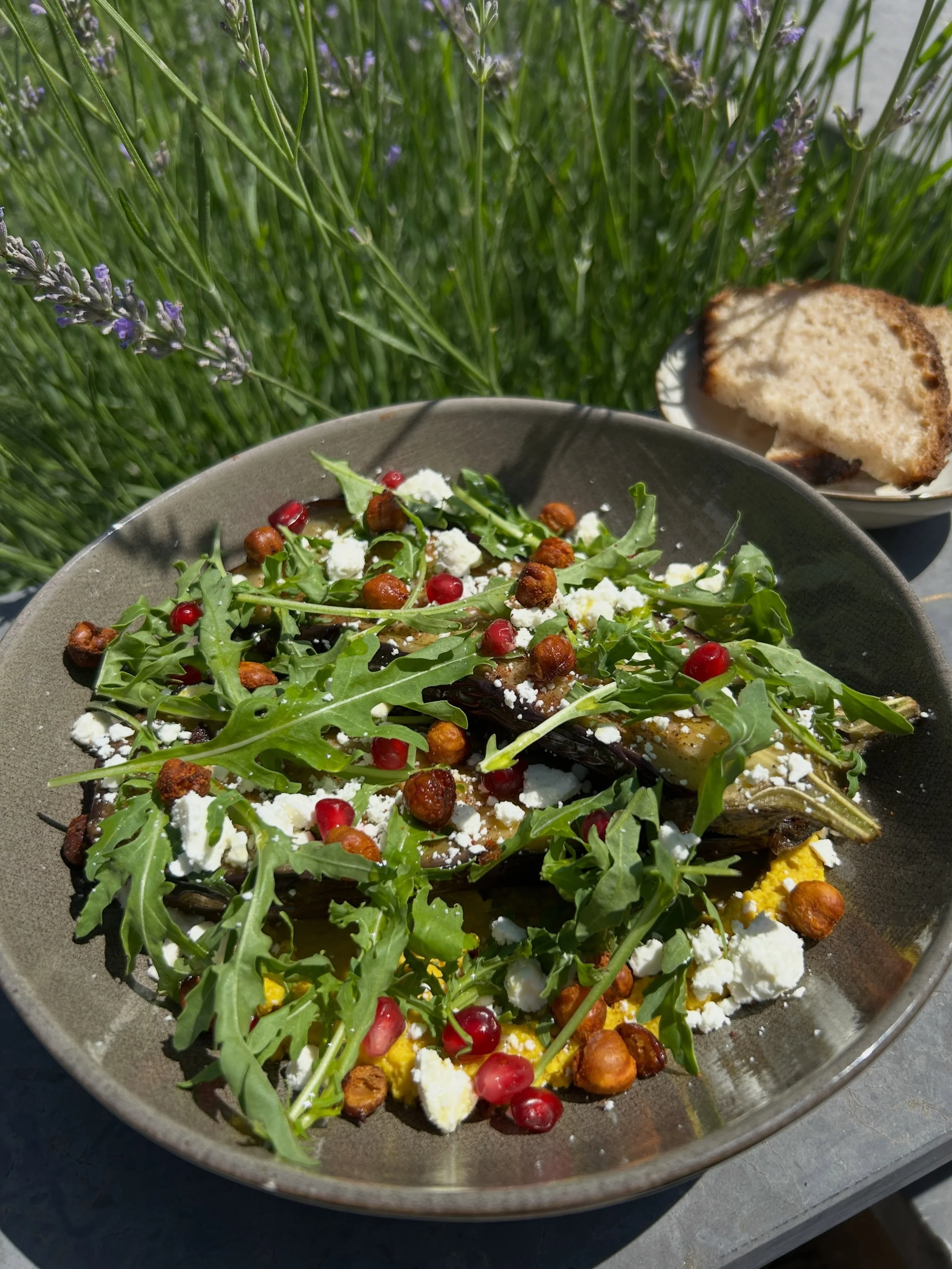 Notre aubergine r&ocirc;tie rencontre un franc succ&egrave;s. 

D&eacute;licatement pos&eacute;e sur un houmous au curry et au curcuma, elle se pare de pois chiches grill&eacute;s, de feta &eacute;miett&eacute;e, de coriandre fra&icirc;che et de grai