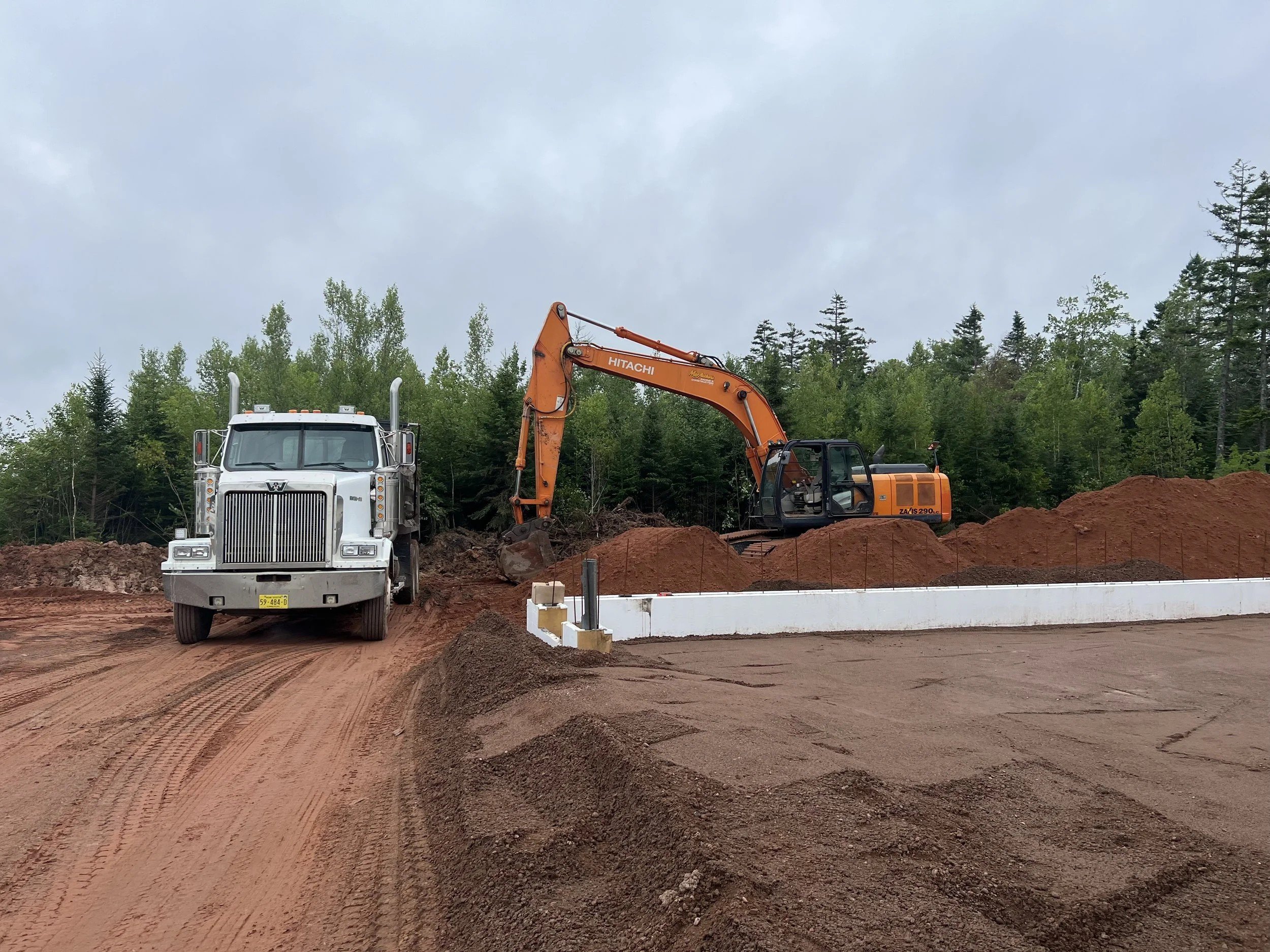 Dump truck and excavator working on a subdivision road build