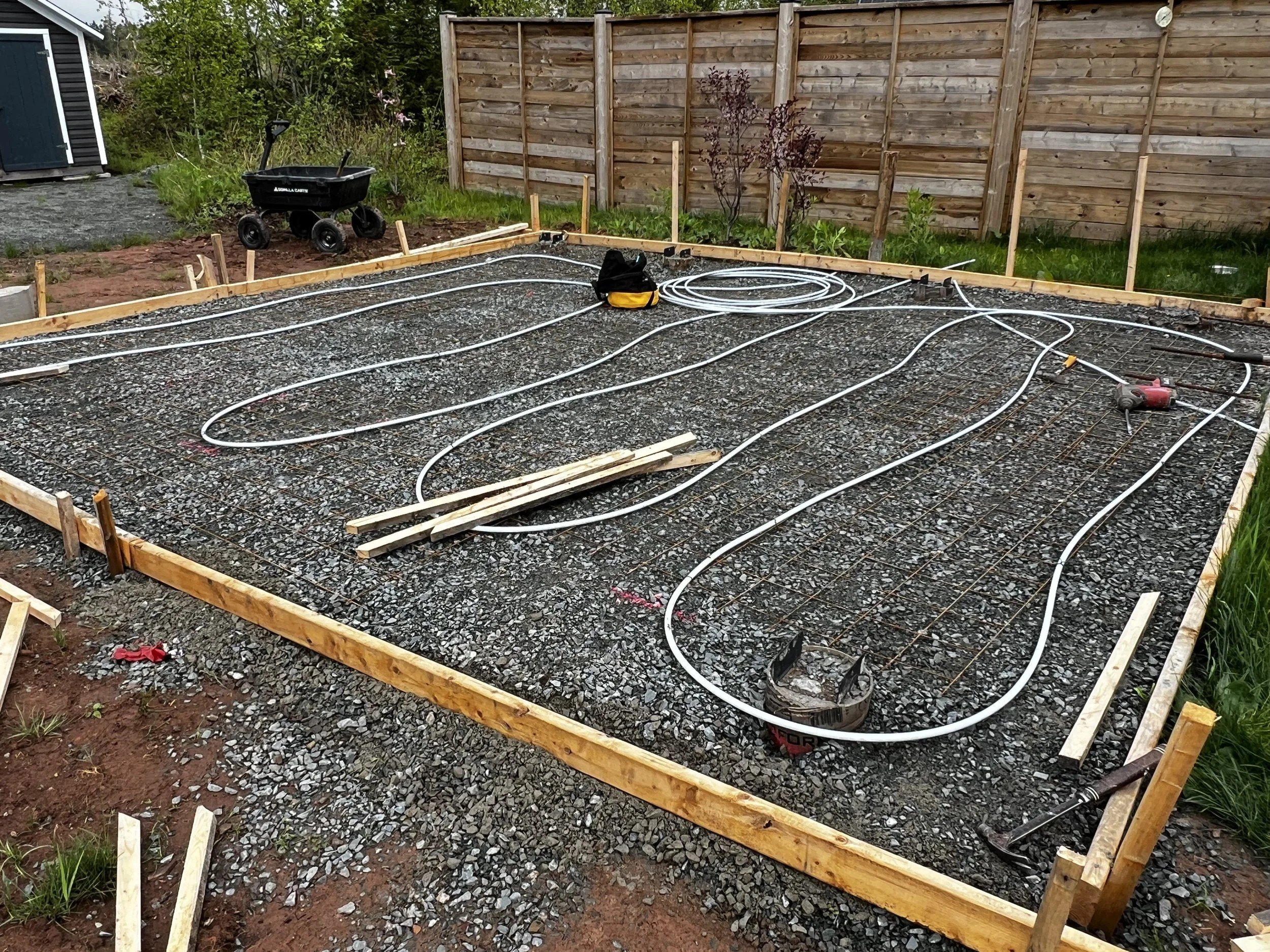 Foundation formwork and prepared gravel base at a custom home site