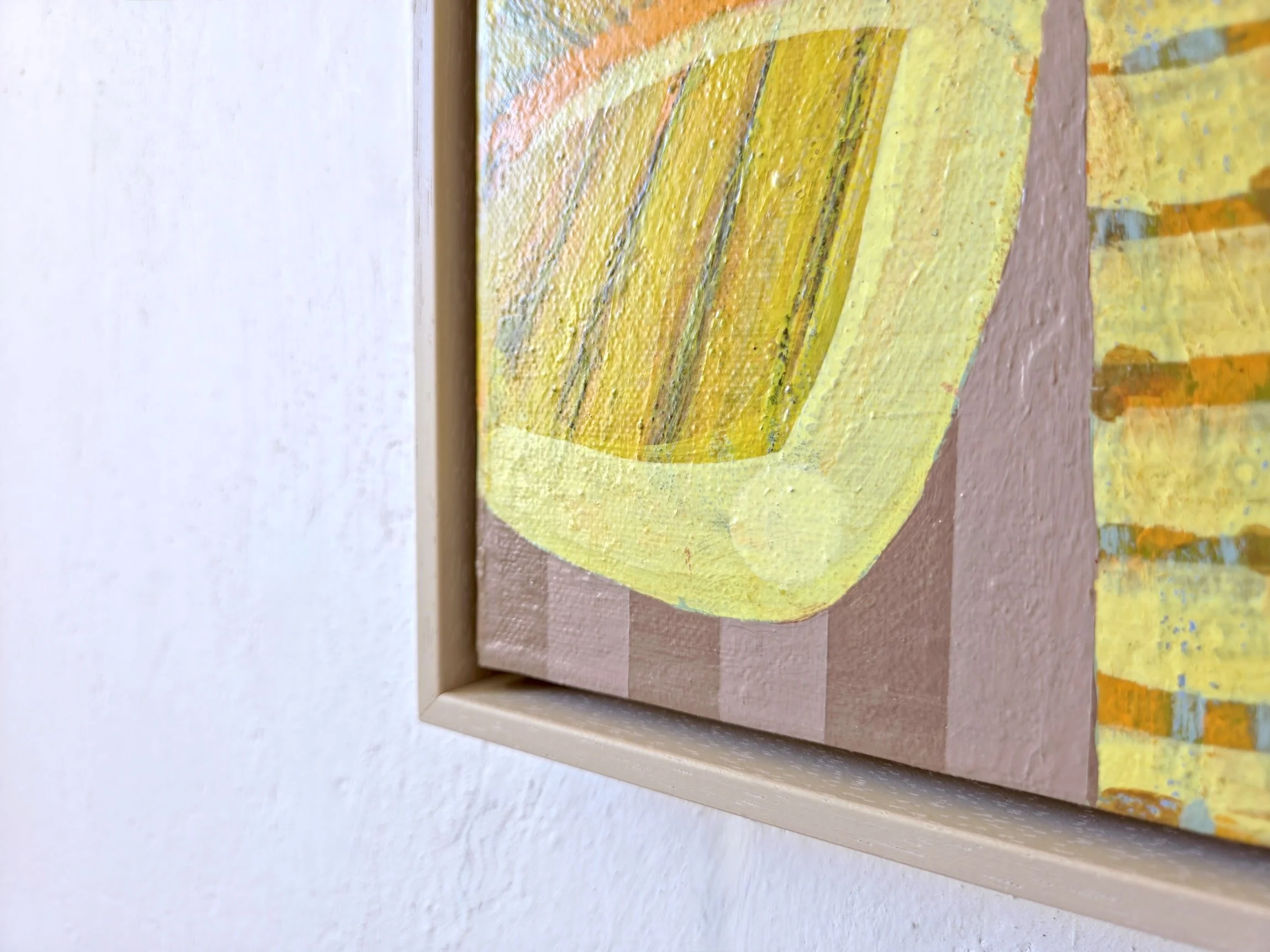 detail of framed palm tree painting in bright yellows and pinks