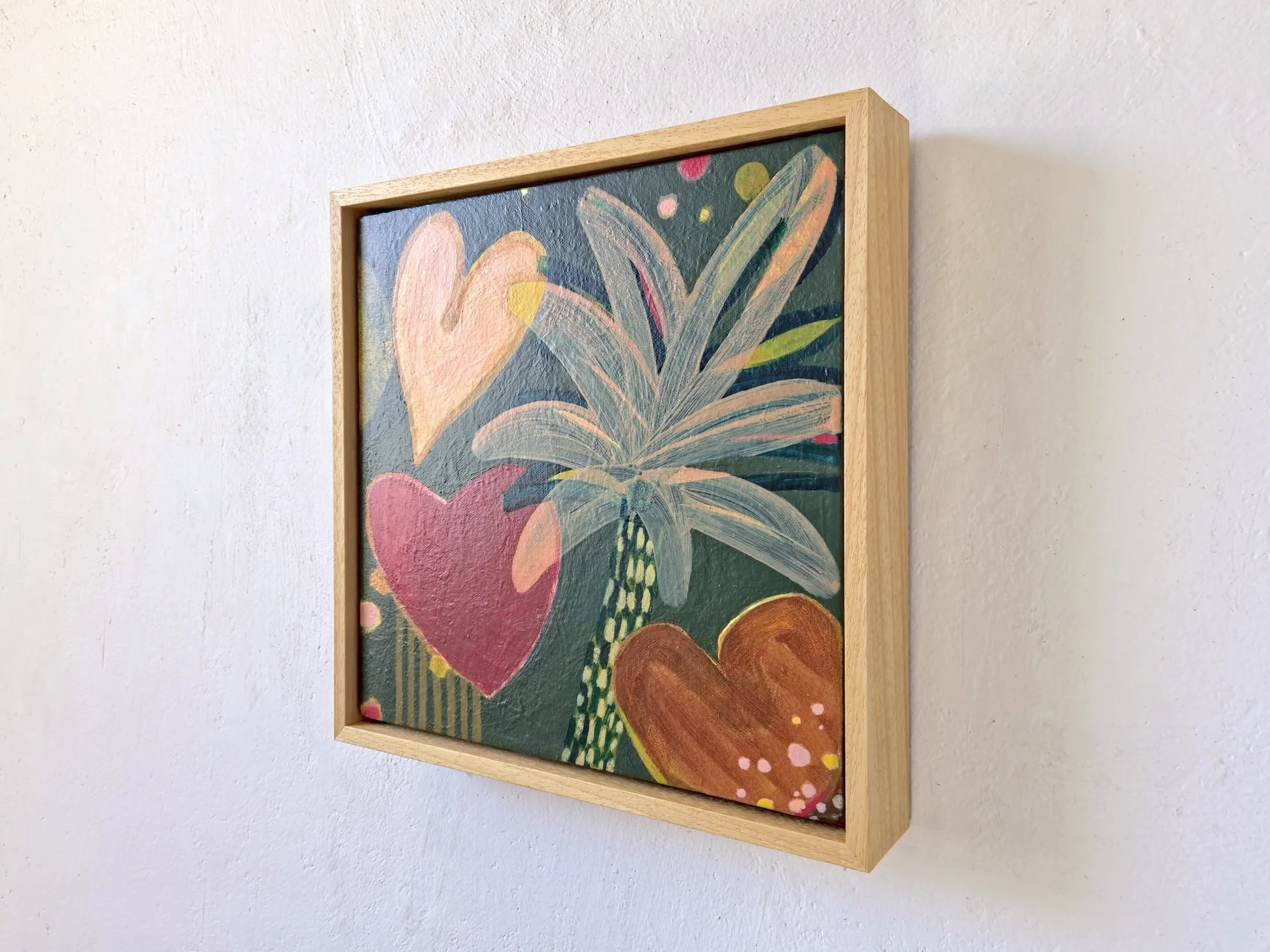 framed botanical painting in red, browns and greens, angled view