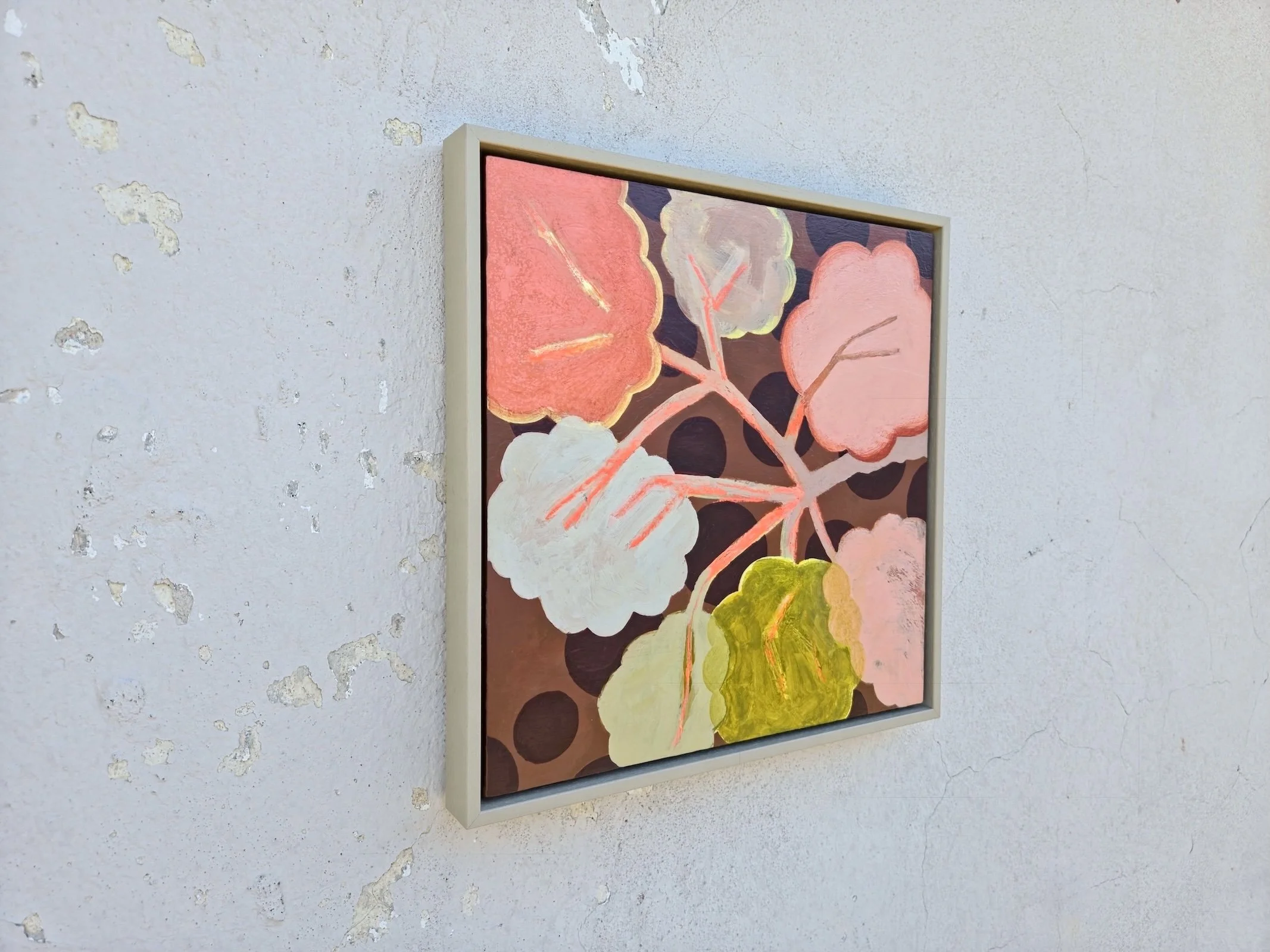 angled view of framed botanical painting in pinks, beige and browns