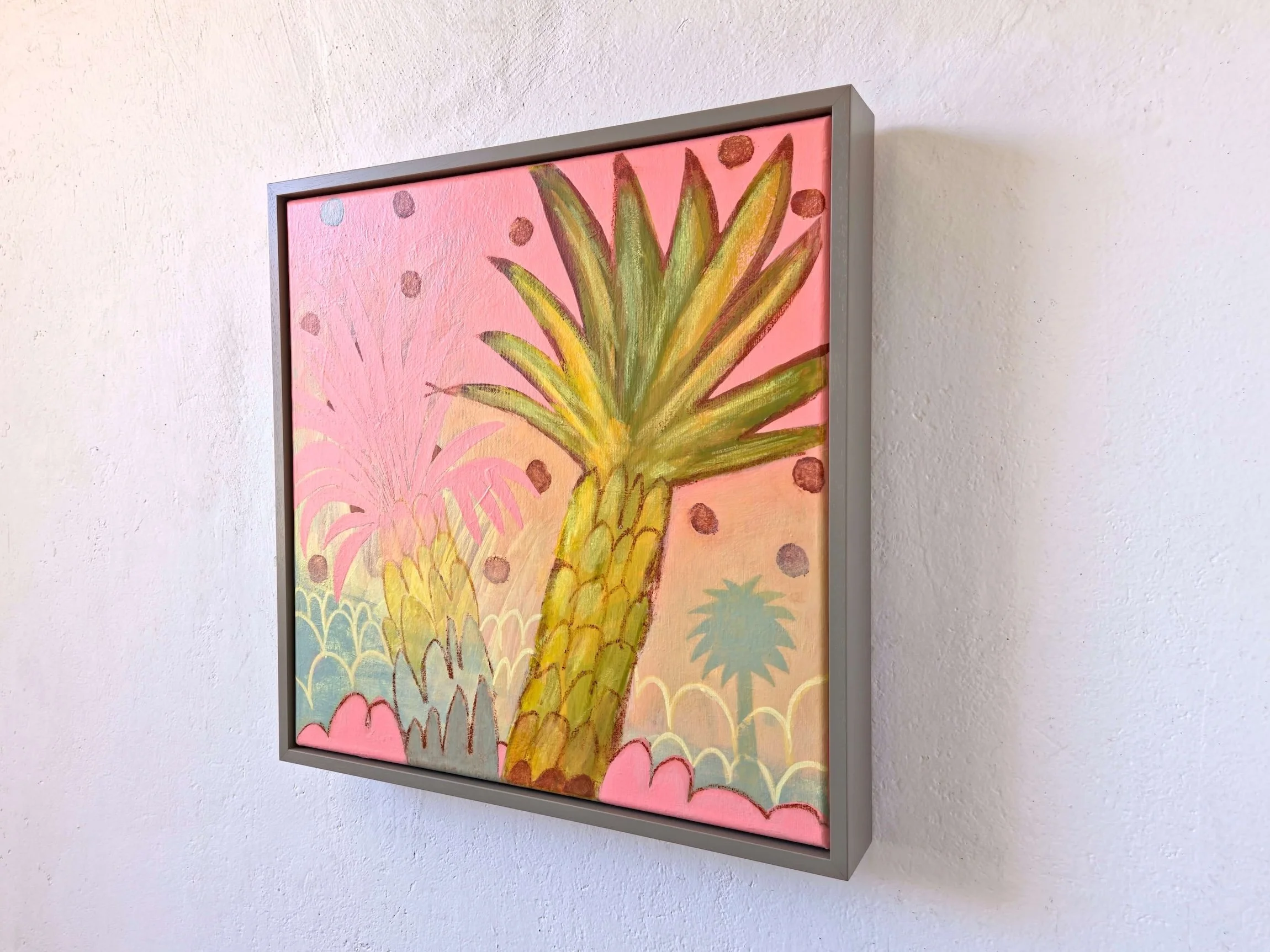 angled view, framed palm tree painting on a vibrant pink background