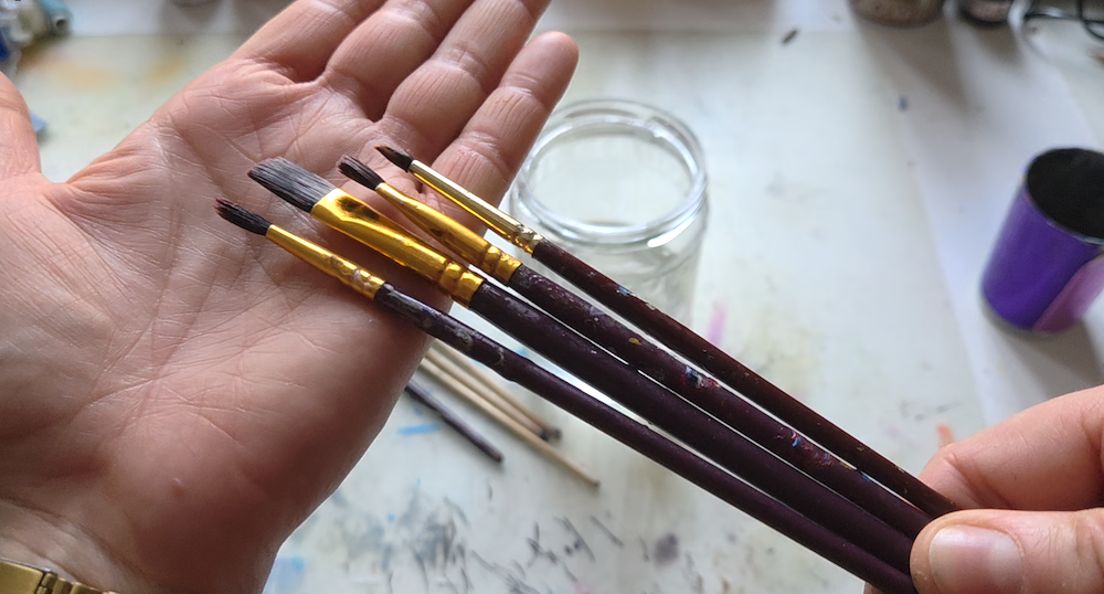 clean brushes in the hand of a woman artist