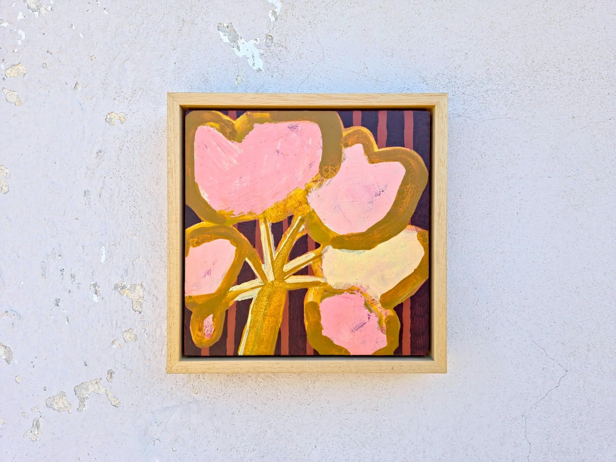 framed botanical painting in pinks and browns on a white wall