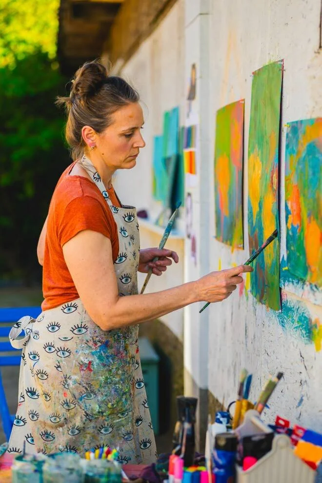 Woman artist painting on her outdoor studio wall