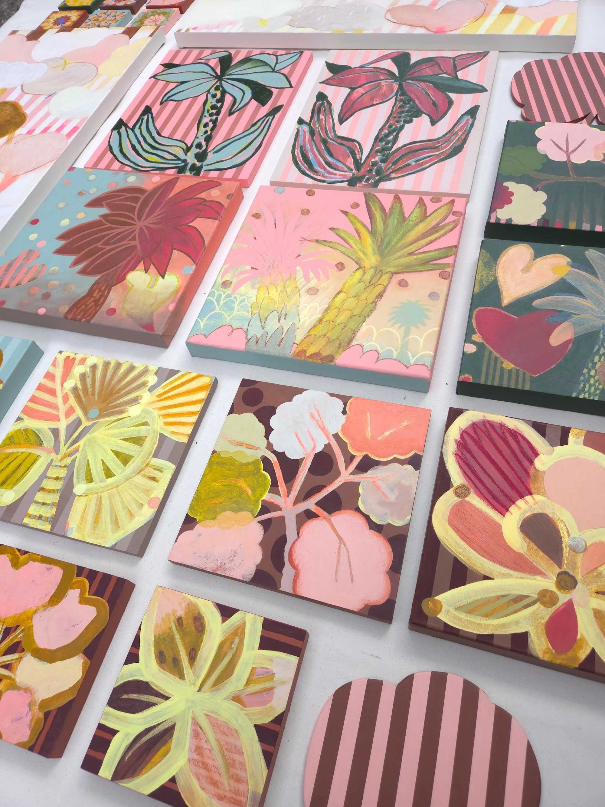 series of canvases painted with colourful botanicals, top view
