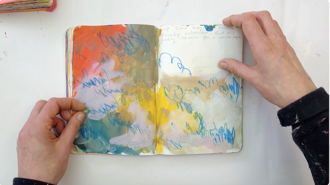 an open sketchbook with a colouful abstract page and the hands of the artist