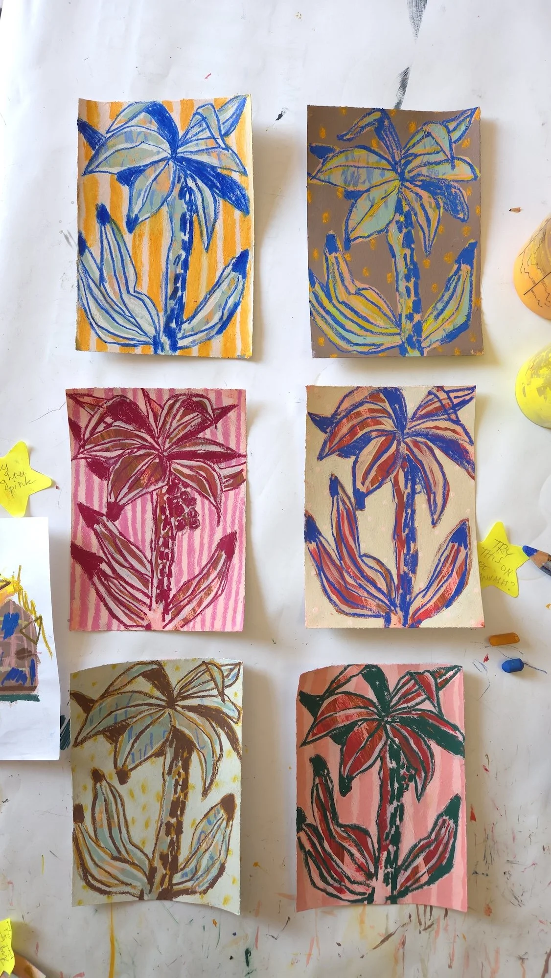 6 studies on paper showing palm trees in various colours
