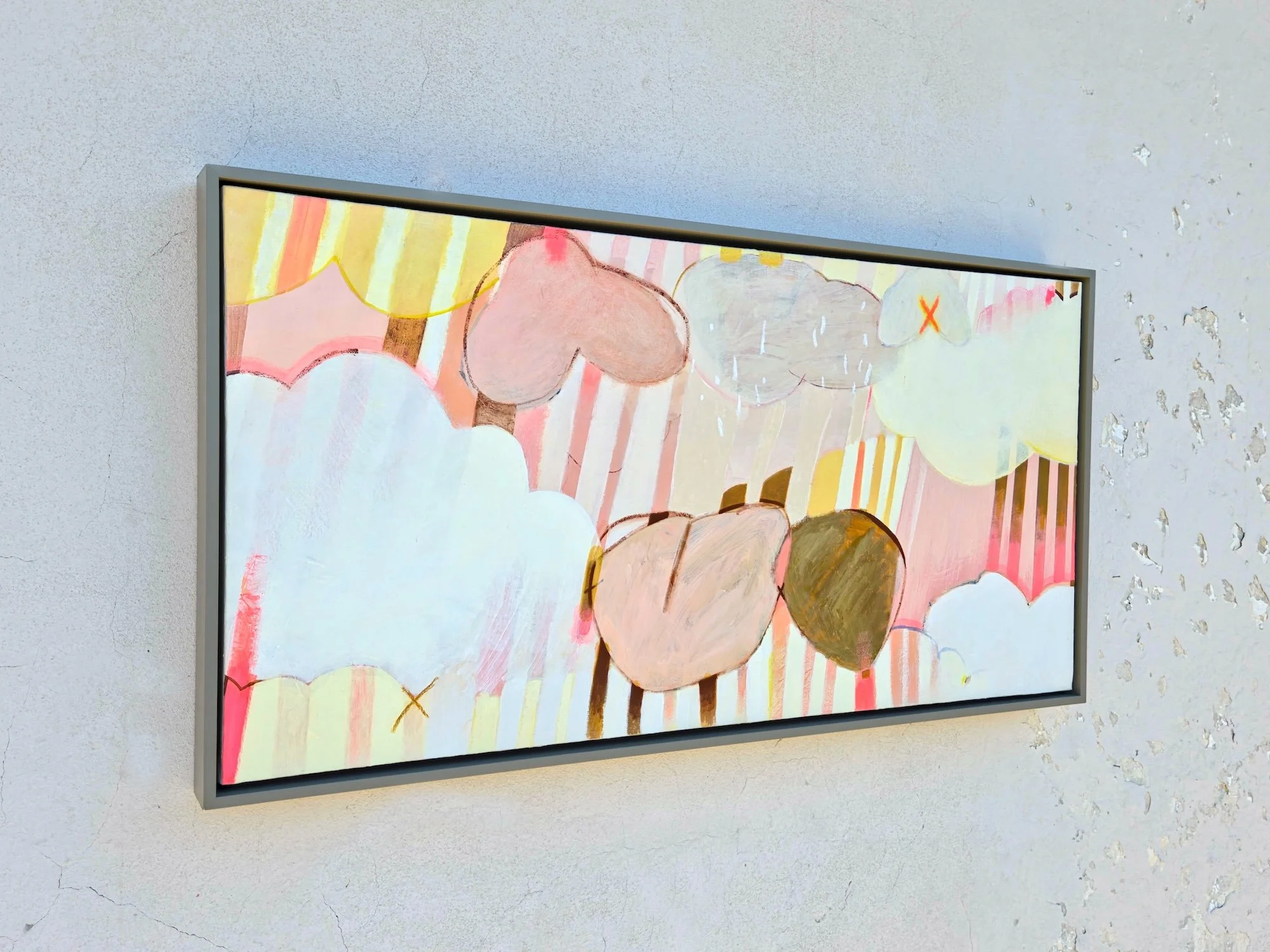angled view of framed botanical painting with colourful striped background