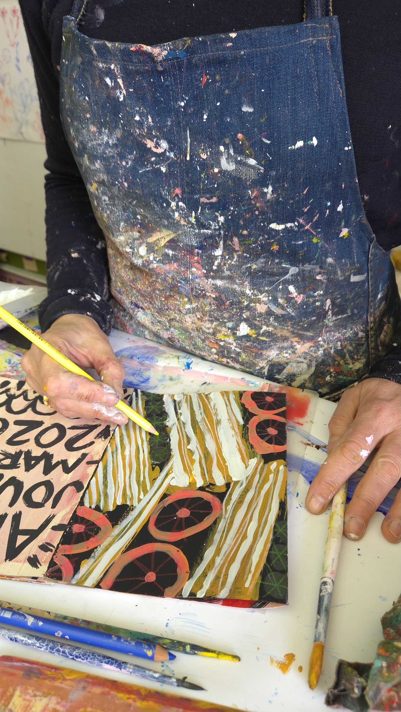 ARTIST working in open sketchbook with colour pencil