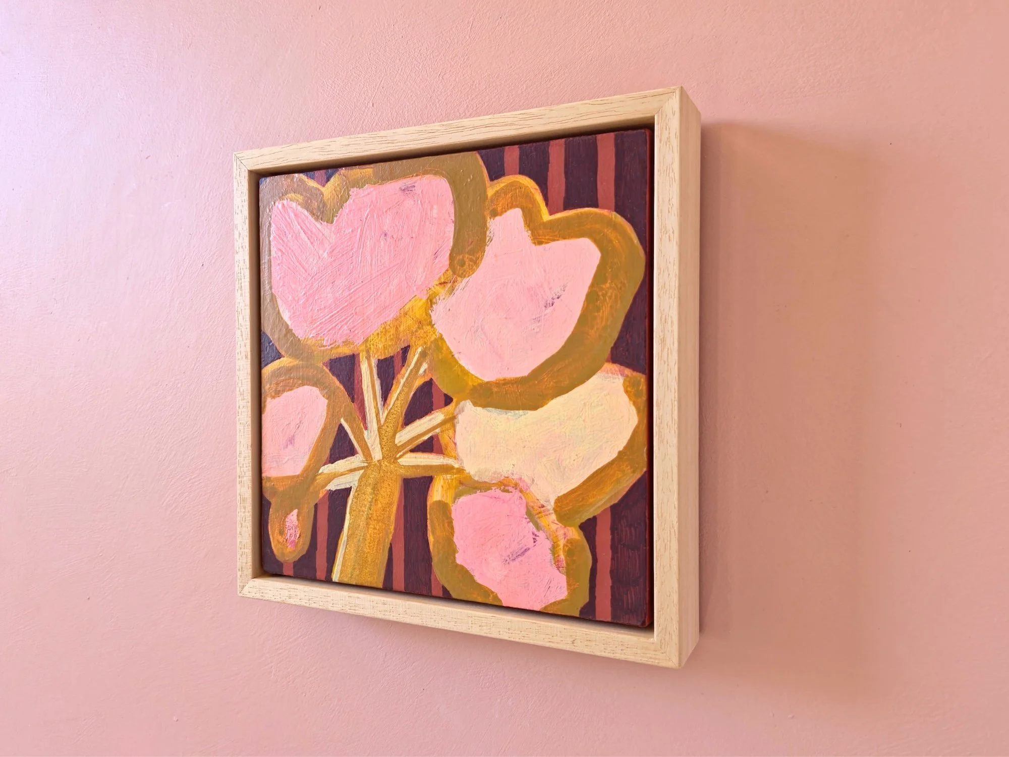 framed botanical painting in pinks and browns on a pink wall