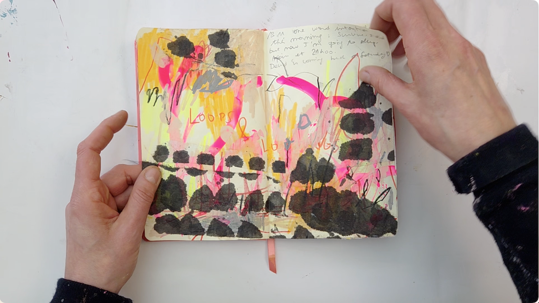 open sketchbooks with pages painted with vibrant colours