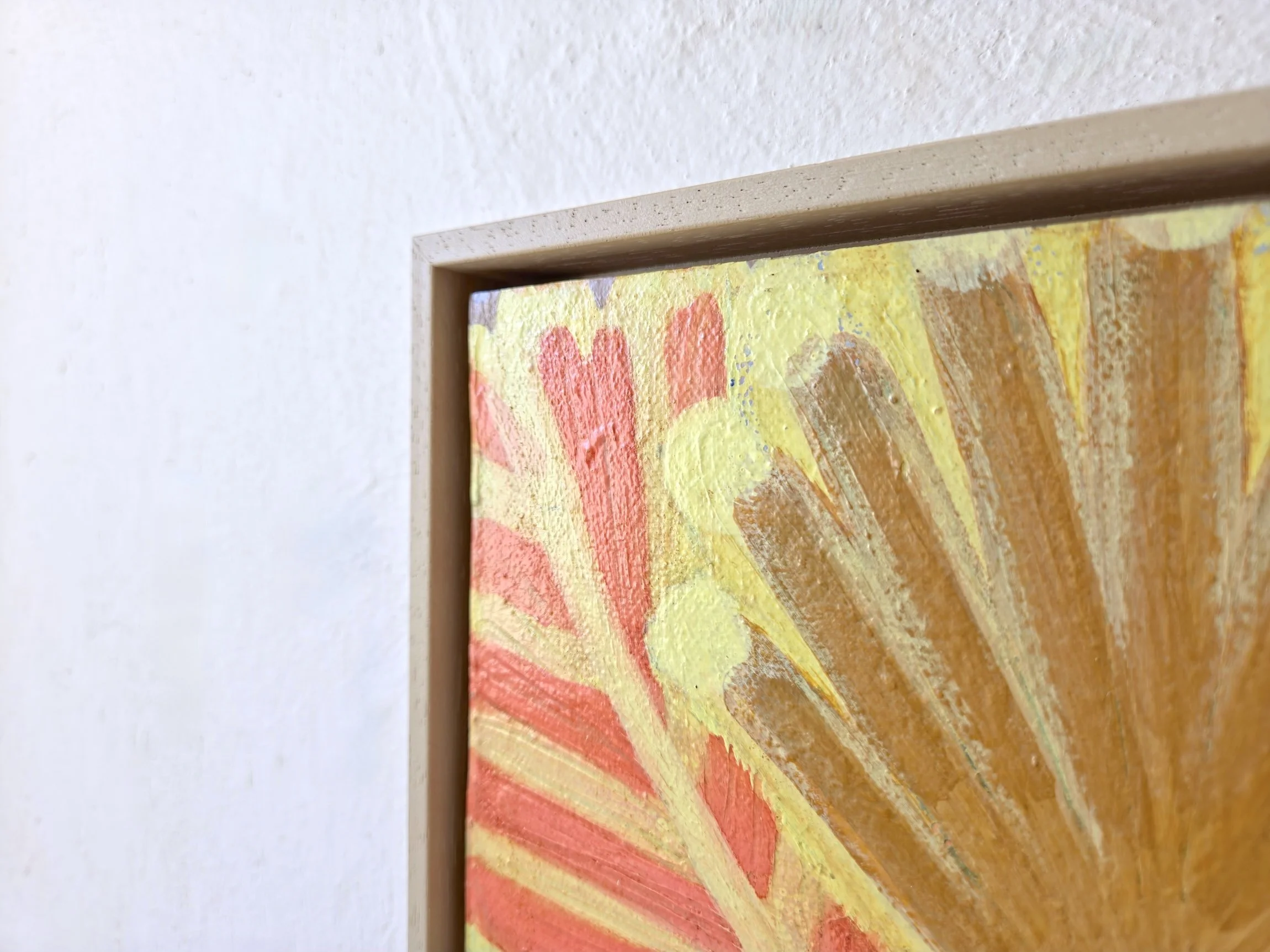 detail of framed palm tree painting in bright yellows and pinks