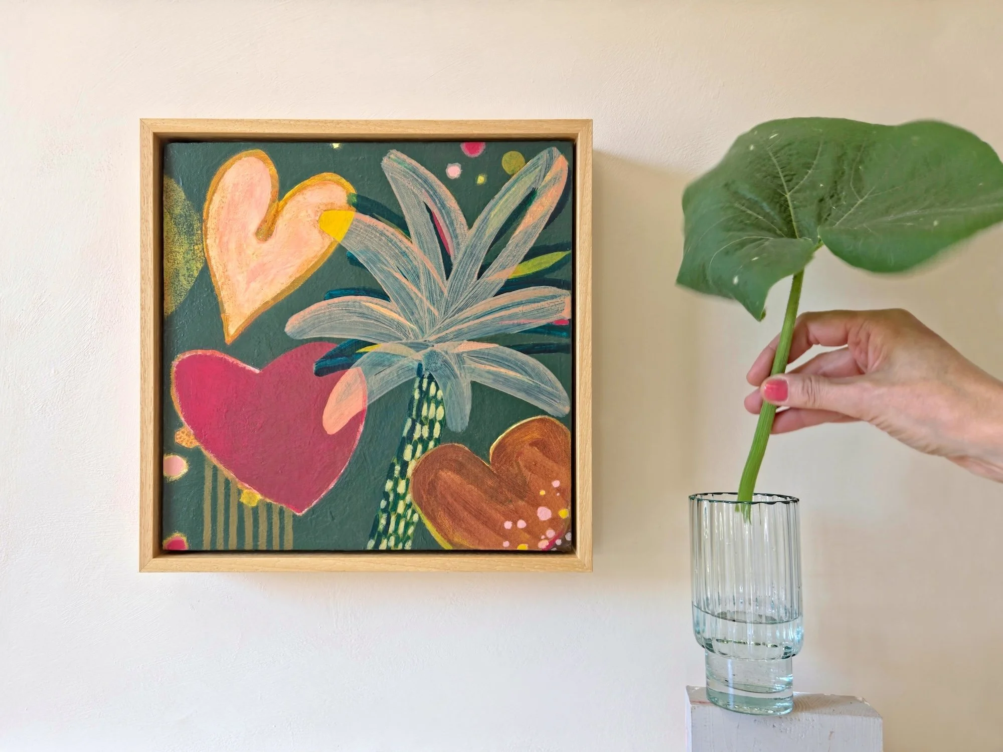 framed botanical painting in red, browns and greens hanged on a white wall
