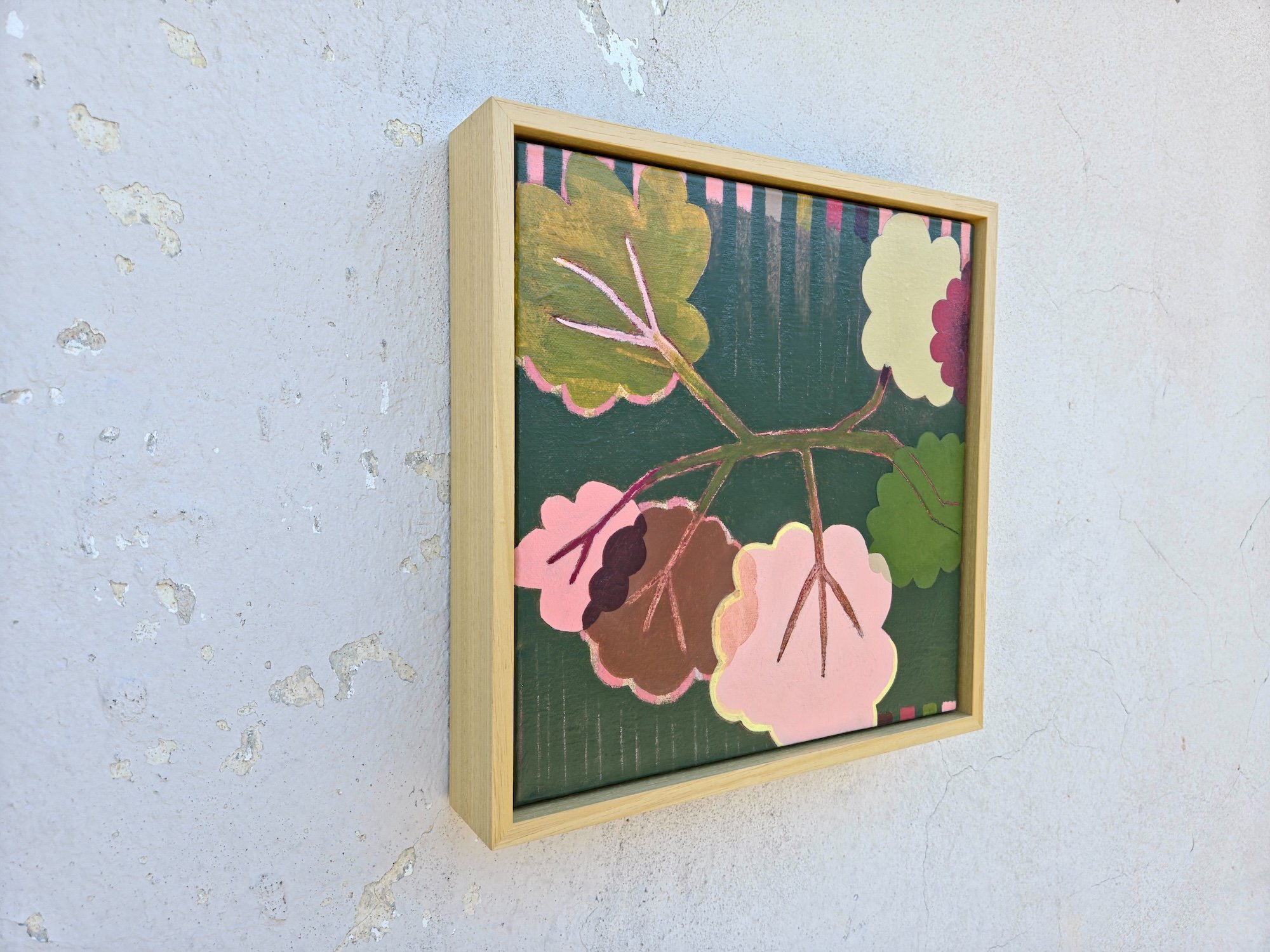 framed botanical painting in pinks and greens, angled view