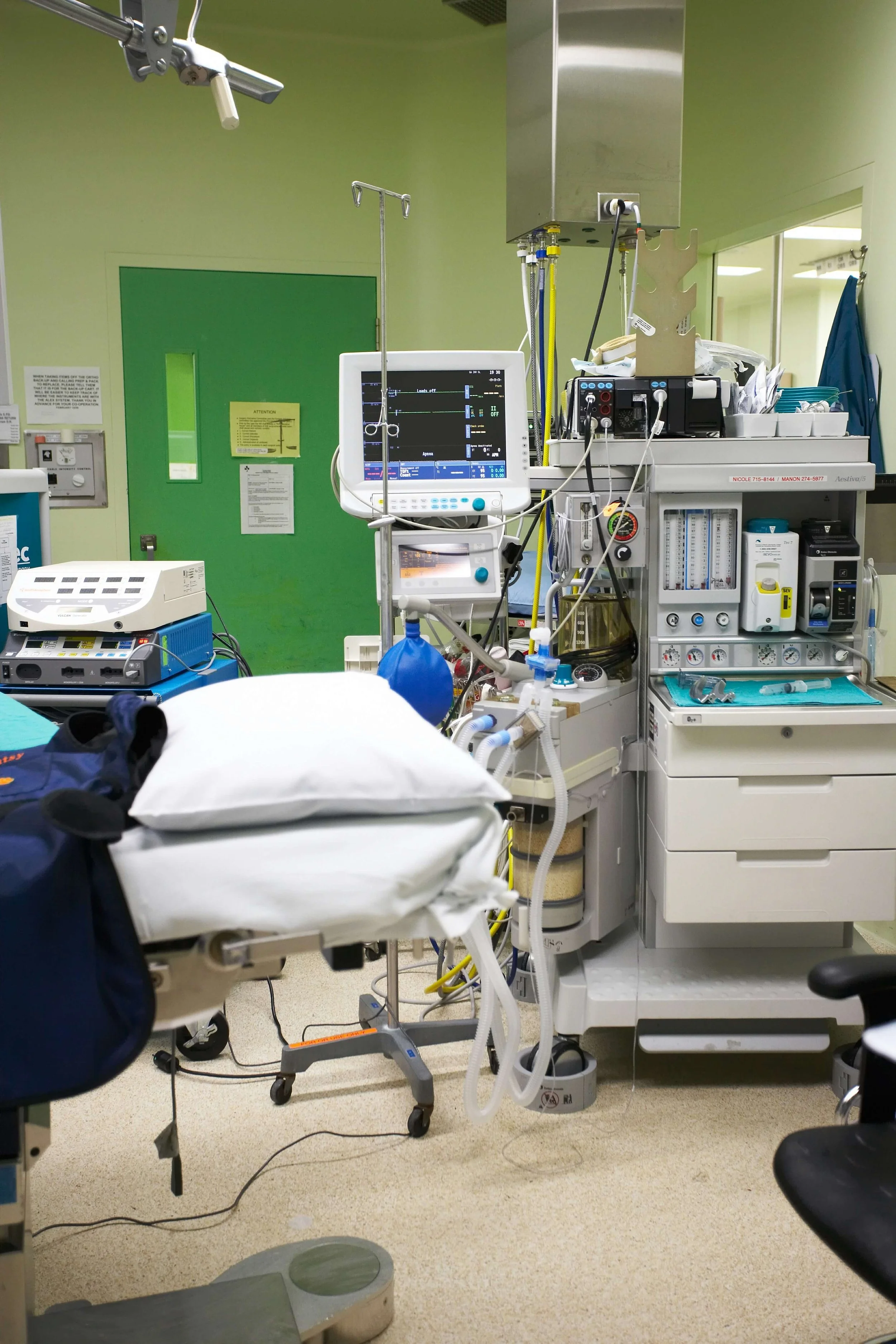 Hospital operating room with medical equipment, monitor, and surgical bed.