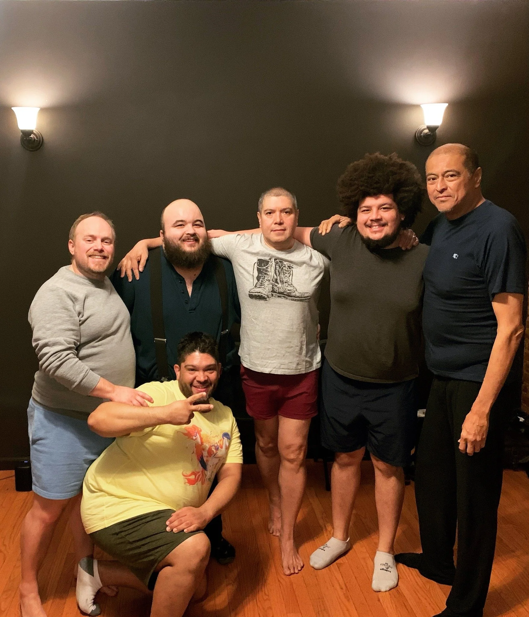 Group of med with their arms around each other posing