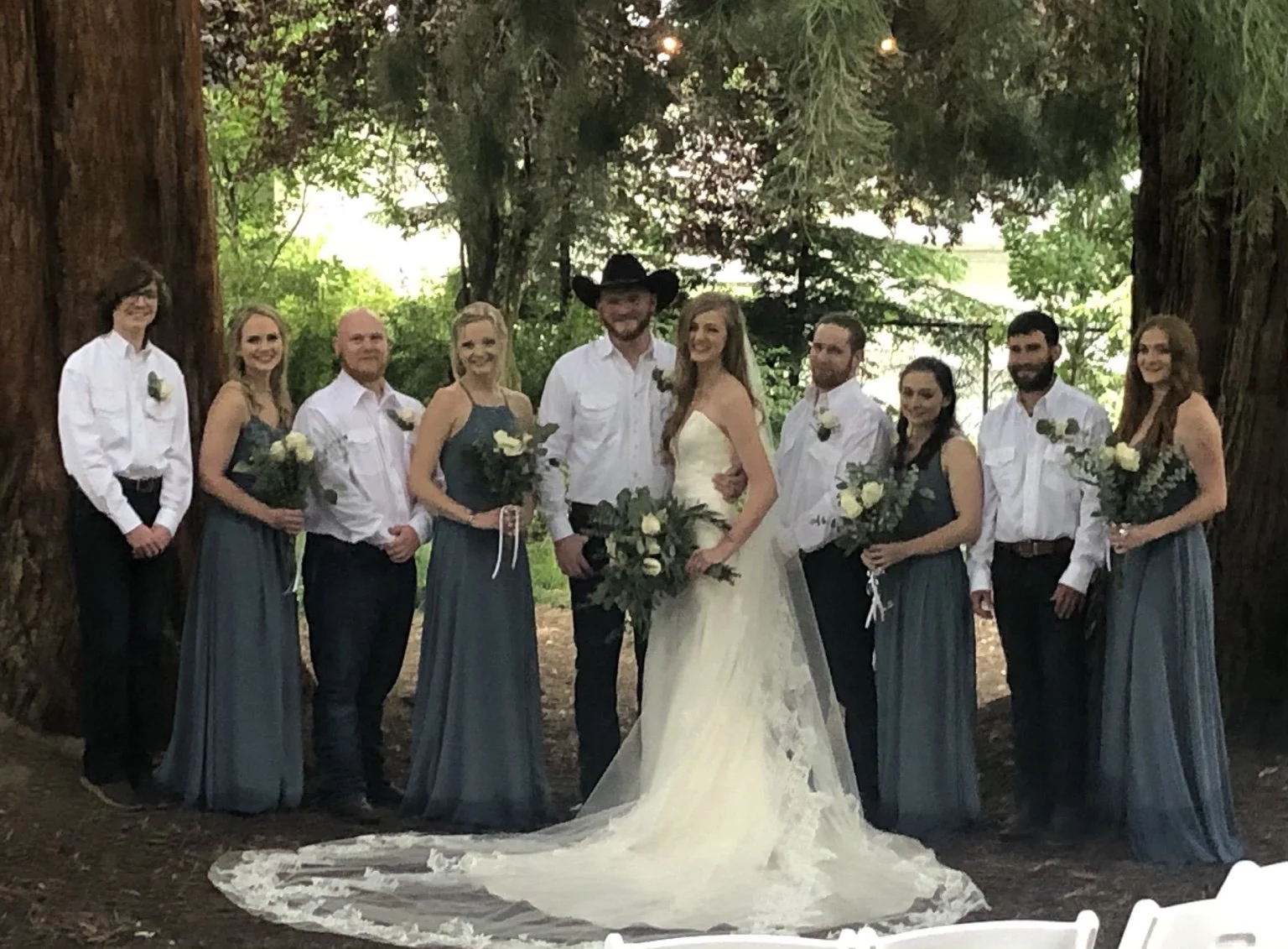 Wedding party gathered beneath the mature trees at Old Town Hall Huntsville in Utah’s Ogden Valley.