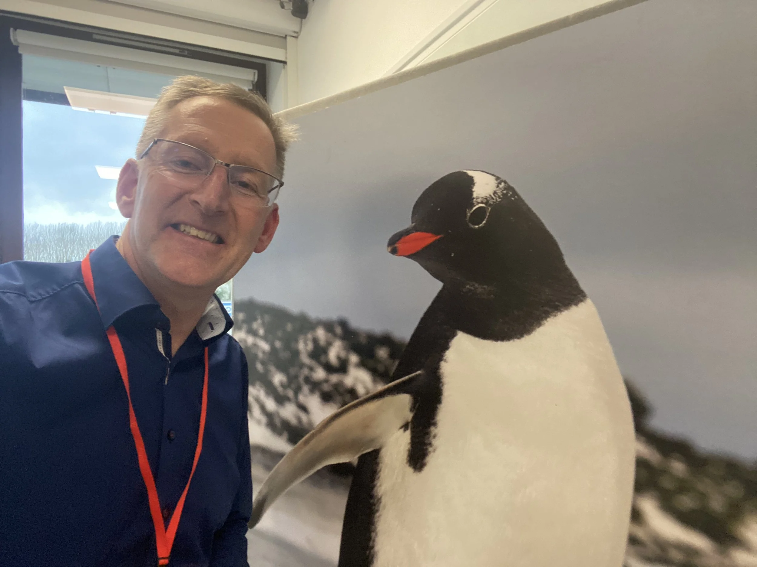 Nigel Thompson next to a penguin. at the British Antarctic Survey