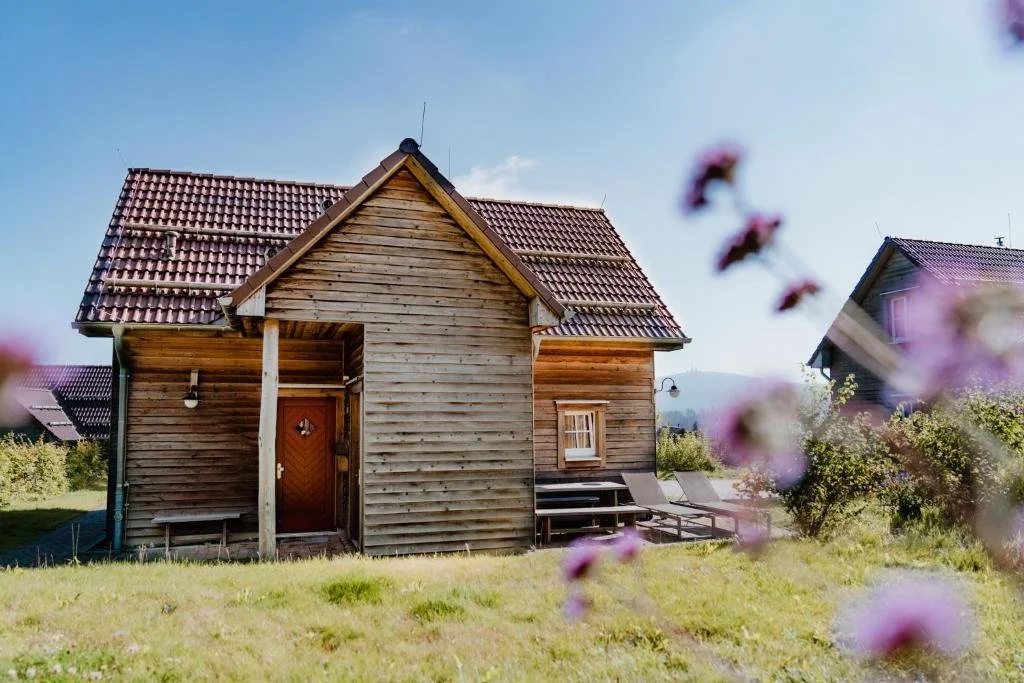 Holzlodge des Torfhaus Harzresorts mit Liegen auf der Terrasse