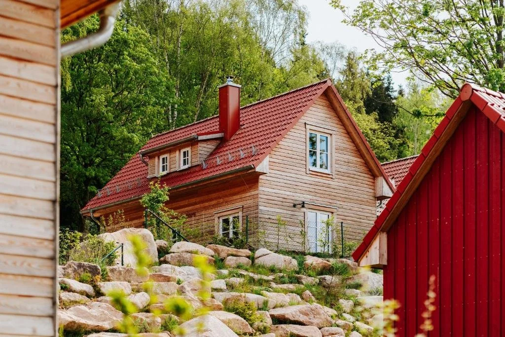 Holzhaus mit rotem Dach im Schierke Harzresort am Waldrand