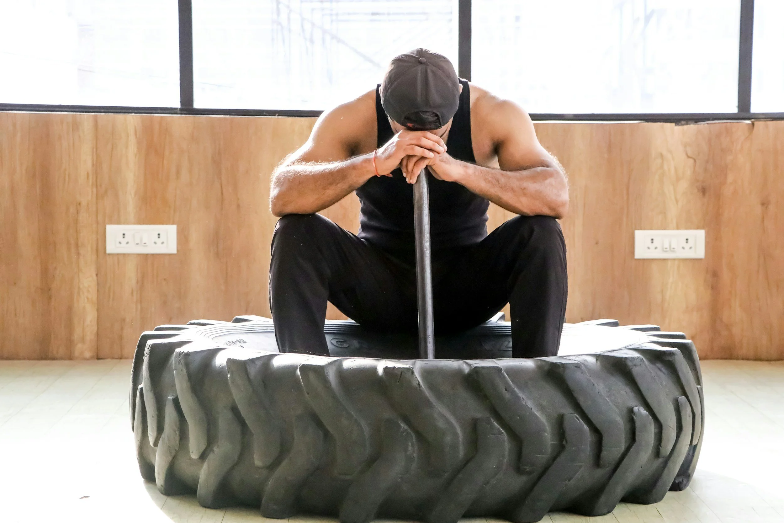 Athlete sitting quietly with eyes fixed downward, processing somatic responses during a Brainspotting session at their training facility
