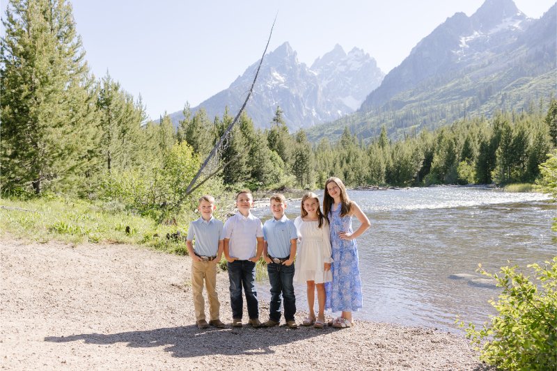 Three boys and two girls posing behind a lake as things to do at Grand Teton.