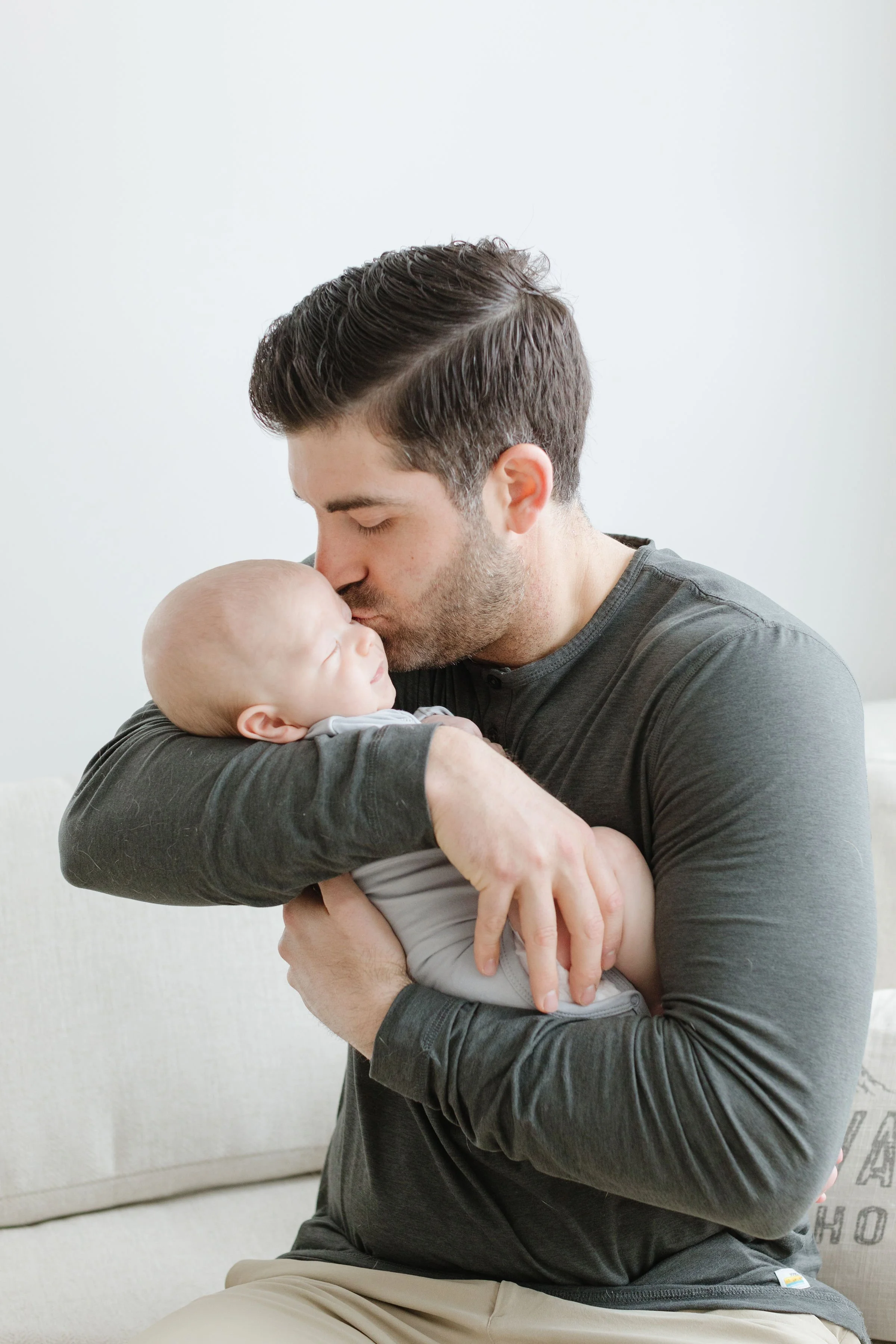  Dad holds baby as a newborn photographer in Jackson Hole captures their photograph. 