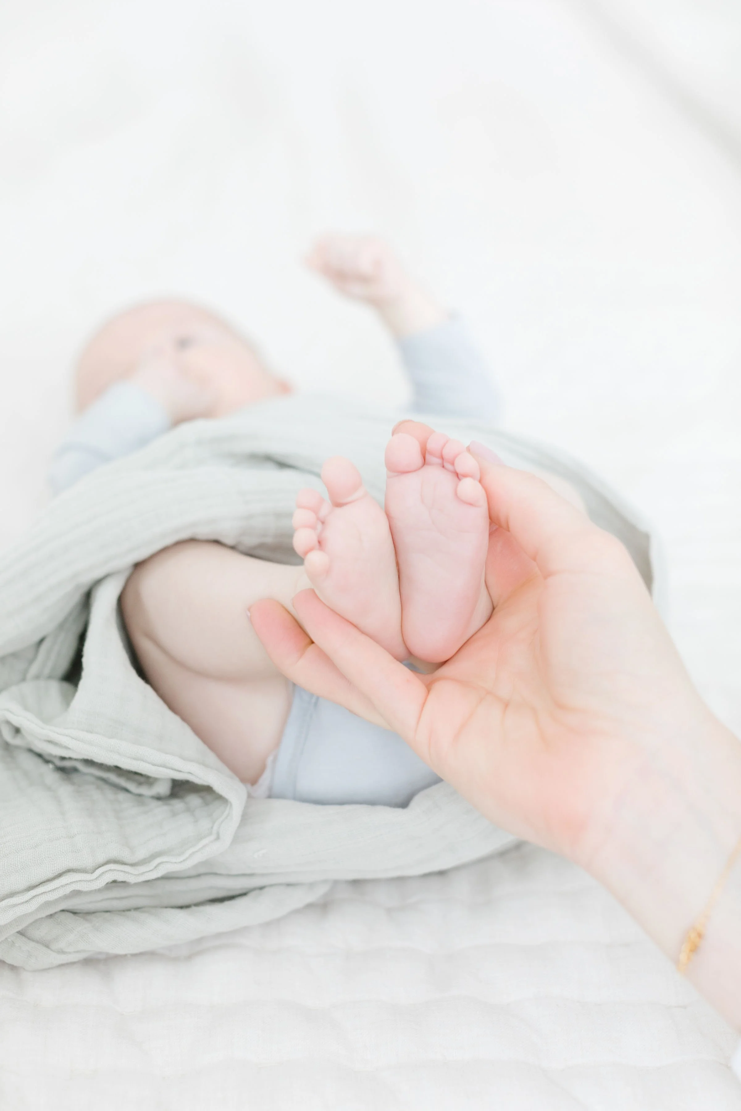  Parent holds baby’s feet as newborn photographer in Jackson Hole captures their detail.  