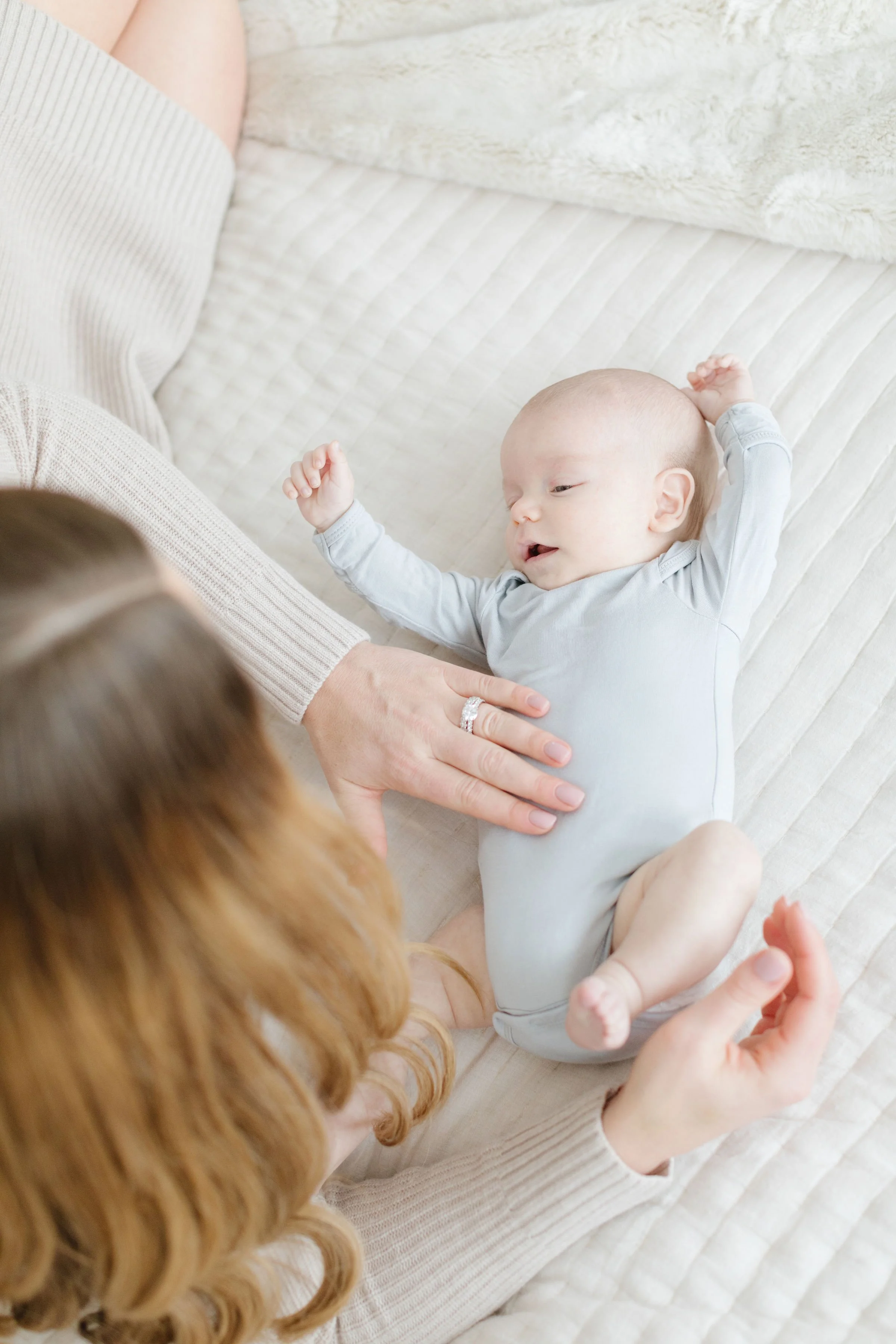  Mom plays with baby as newborn photographer in Jackson Hole captures them. 