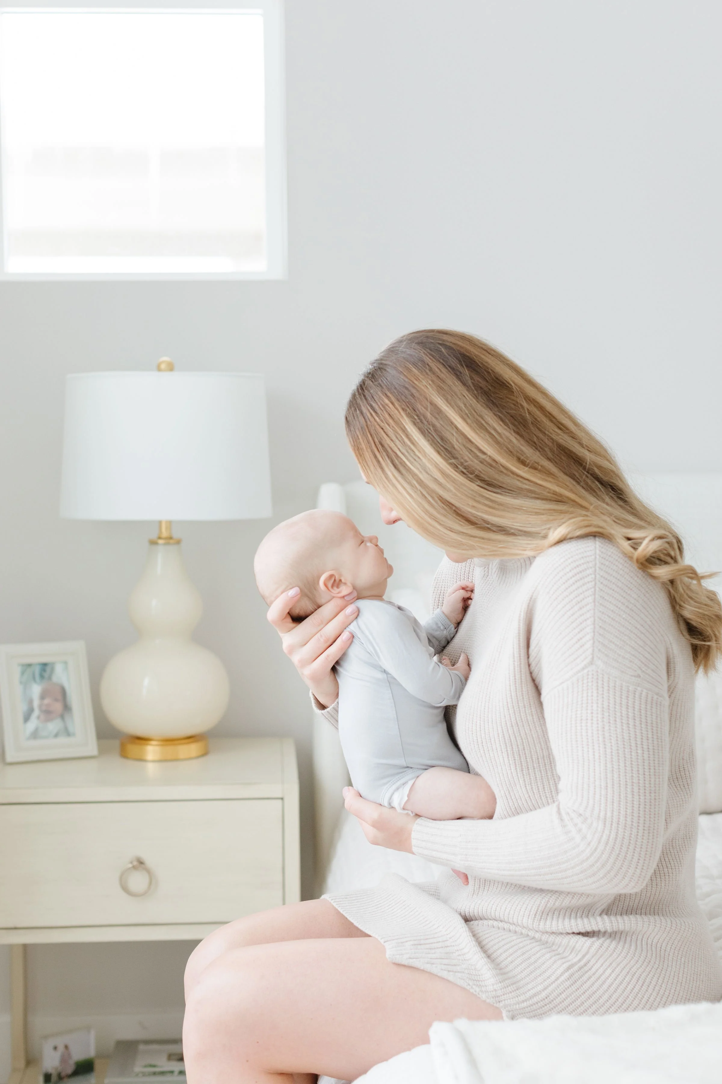  Mom holds baby for in-home session with newborn photographer in Jackson Hole. 