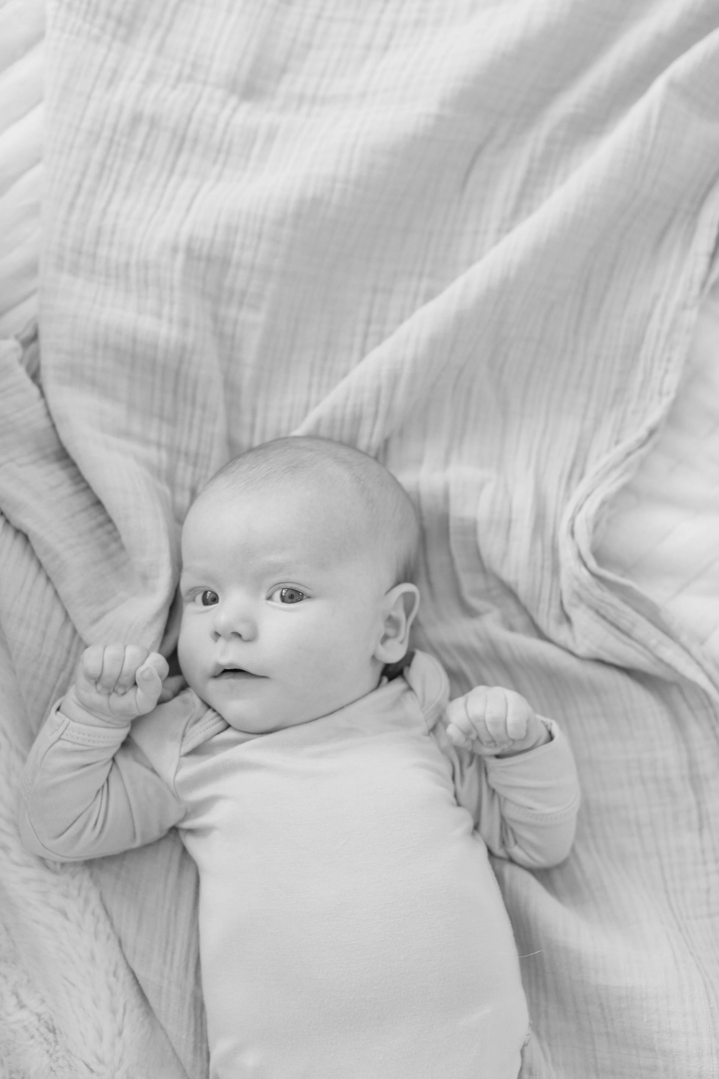  Newborn photographer in Jackson Hole captures baby boy laying on bed.  