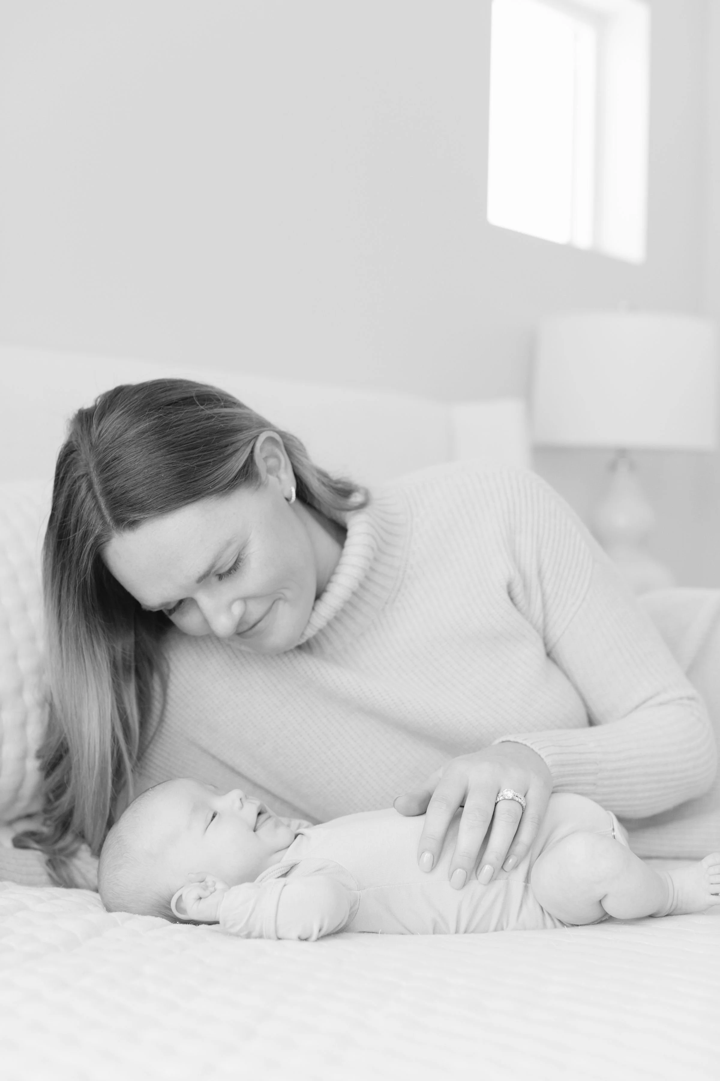  Newborn photographer in Jackson Hole captures baby boy and mom laying on bed.  