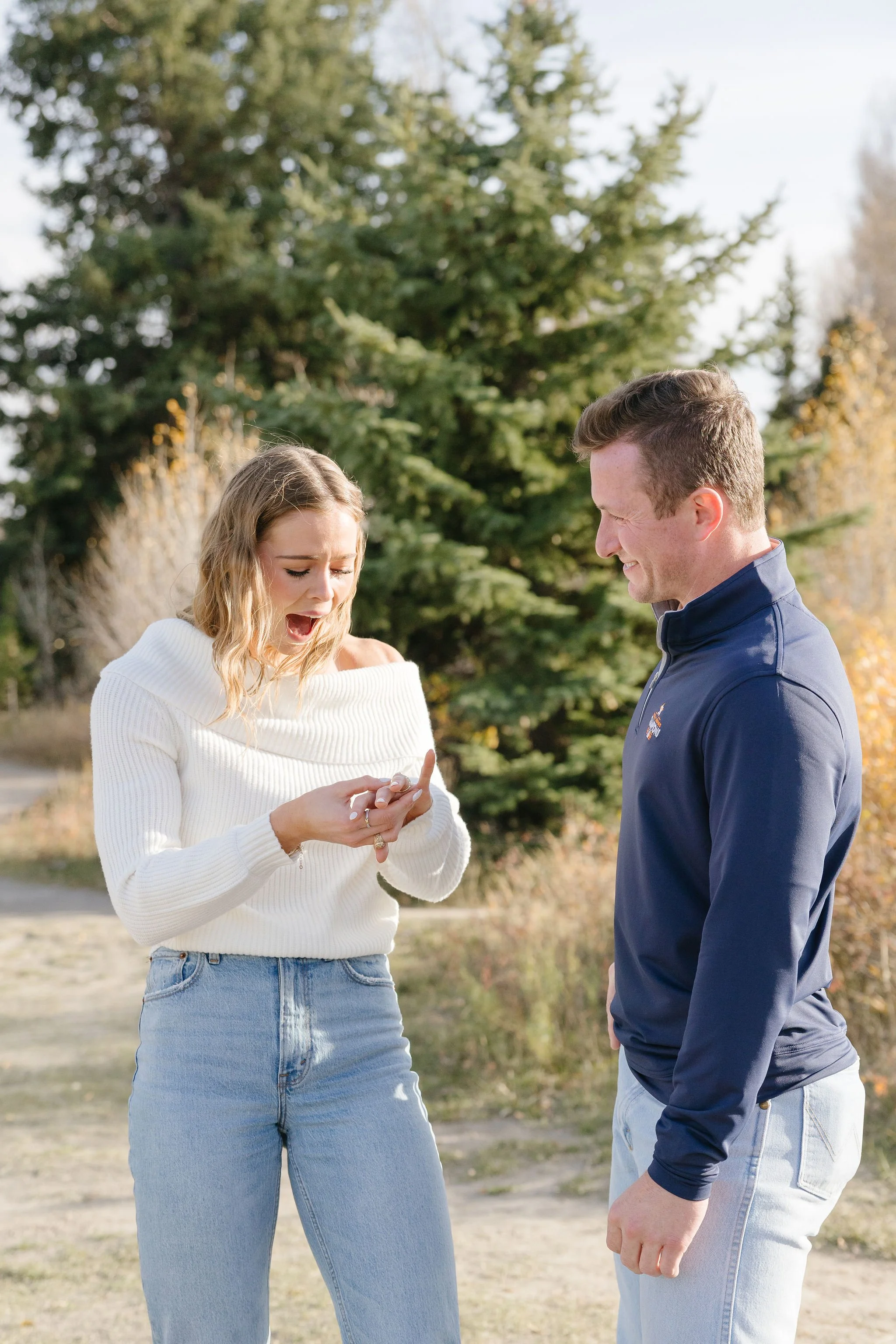  Jackson Hole proposal photographer captures woman as she holds up her hand excitedly, admiring the ring her boyfriend just proposed with. 