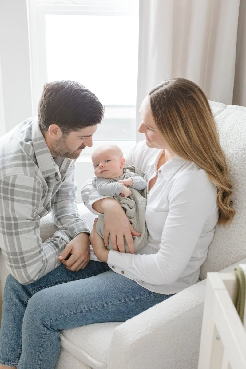  First-time parents in Jackson Hole smile as they hold their baby boy during a newborn photoshoot with Roslyn Smithers. 