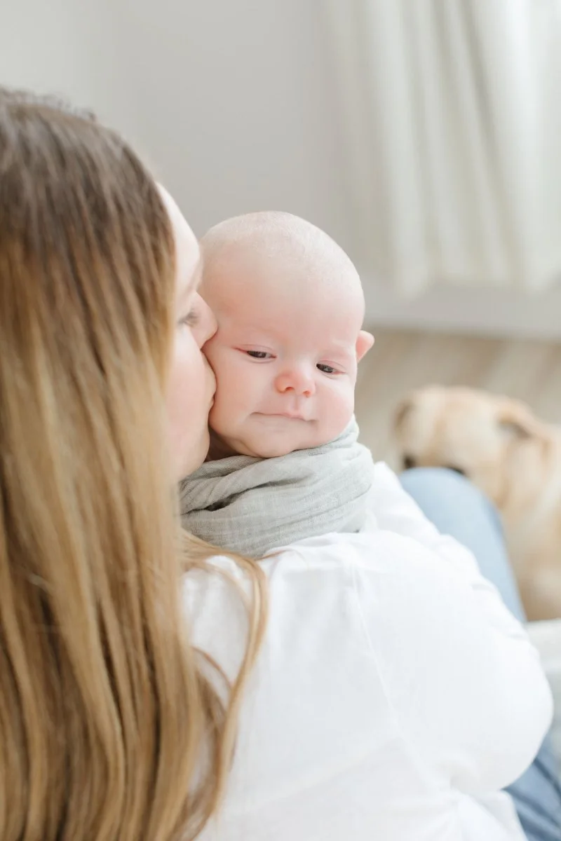  Mom kisses newborn baby on the cheek. 