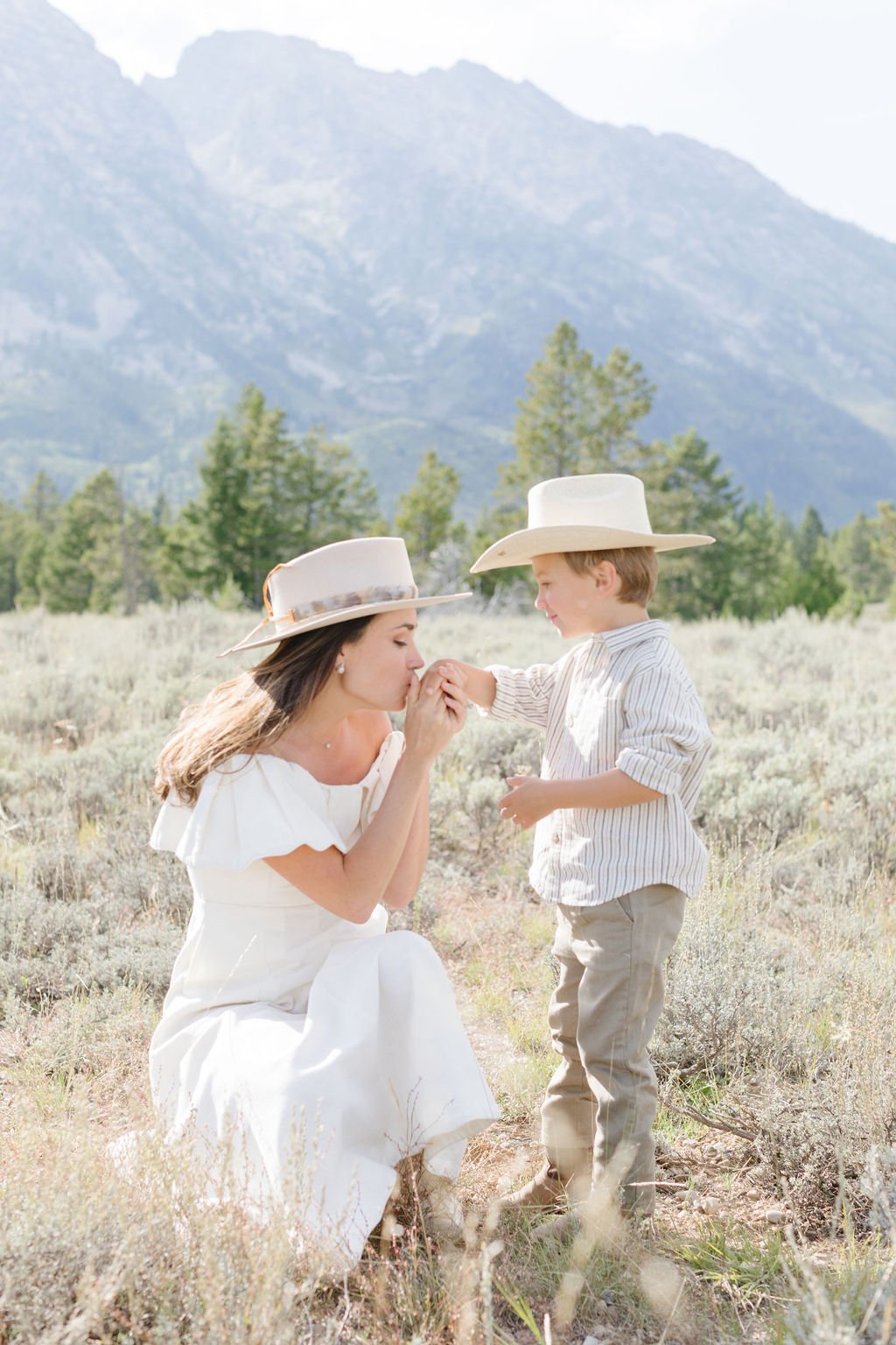  Mother kisses sons hands during western family photos in Jackson Hole. 