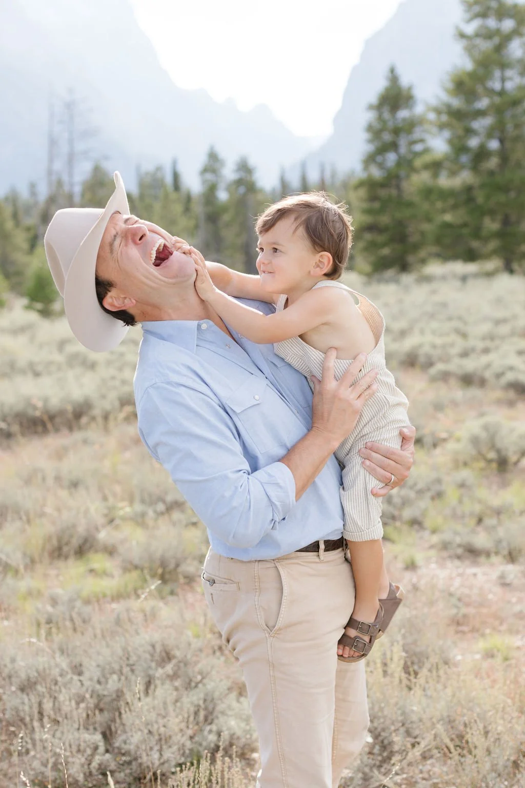  Dad laughs as his son plays with him during family photos. 