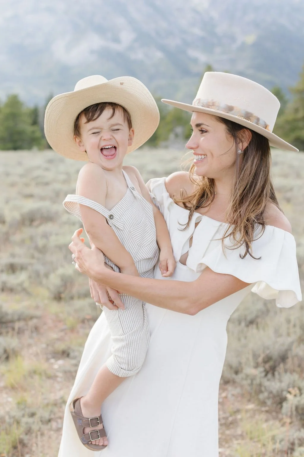  Mother holds smiling toddler during western family photos. 
