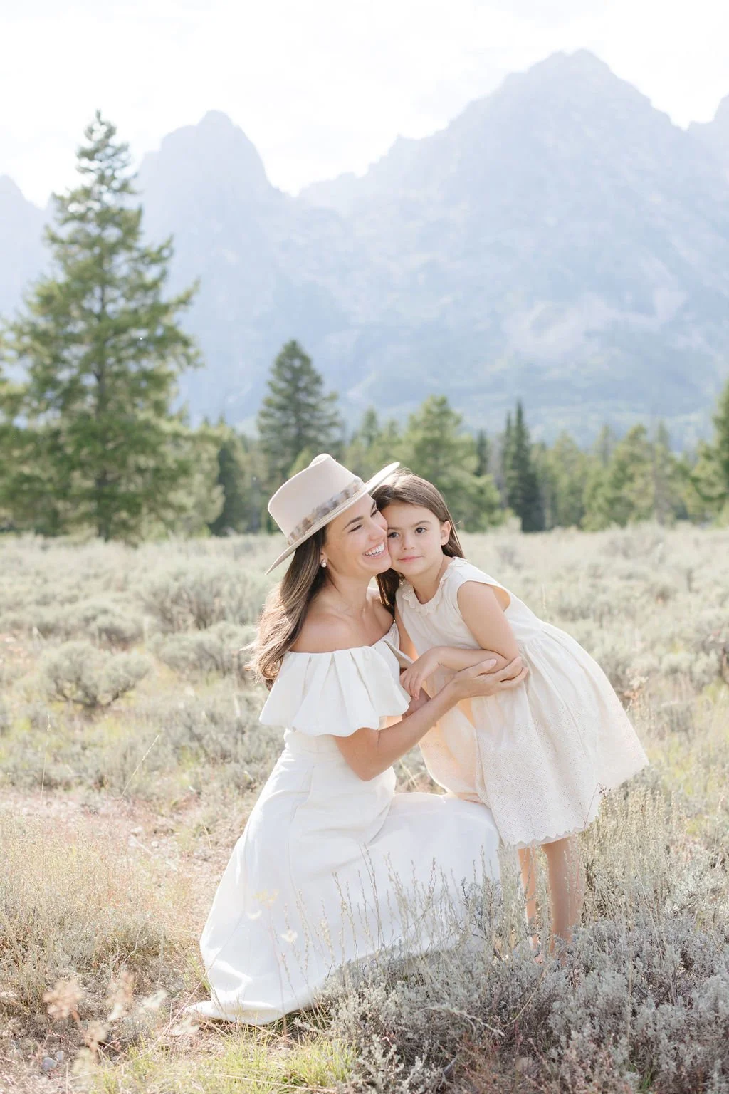  Mother hugs daughter during family photos. 