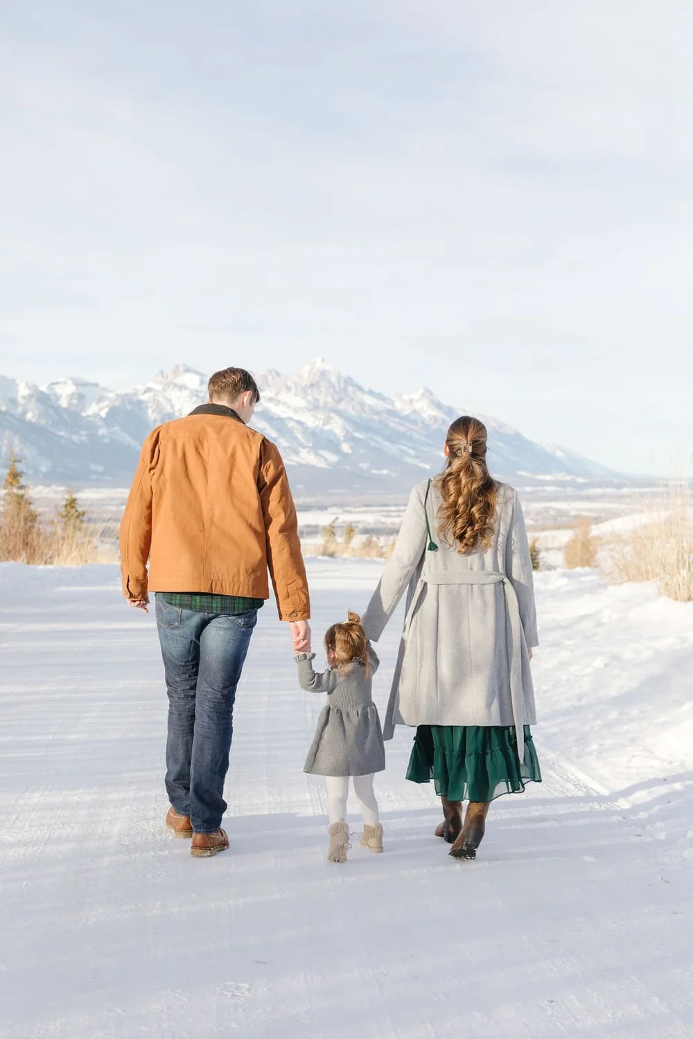  Family walks together hand in hand on a snow covered trail in Jackson Hole for their holiday card photoshoot. 