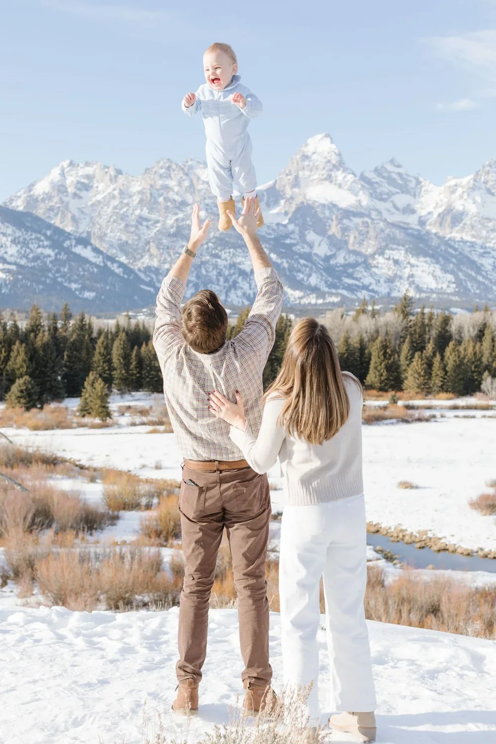  Father tosses baby into the air as their family does a holiday card photoshoot in Jackson Hole. 