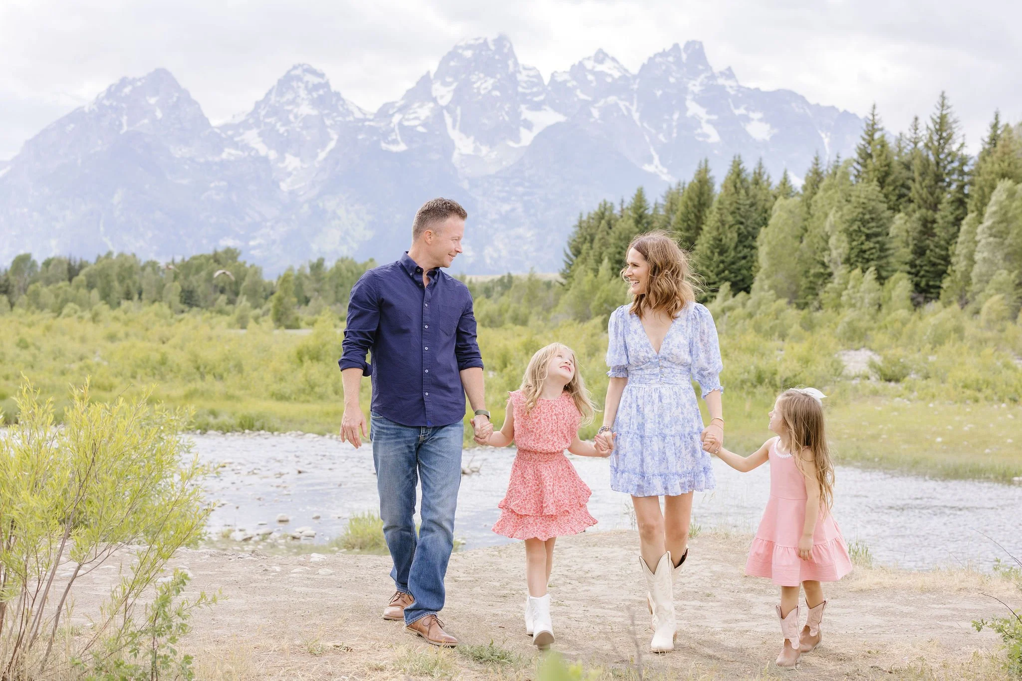  Family walks together holding hands during a photoshoot. 