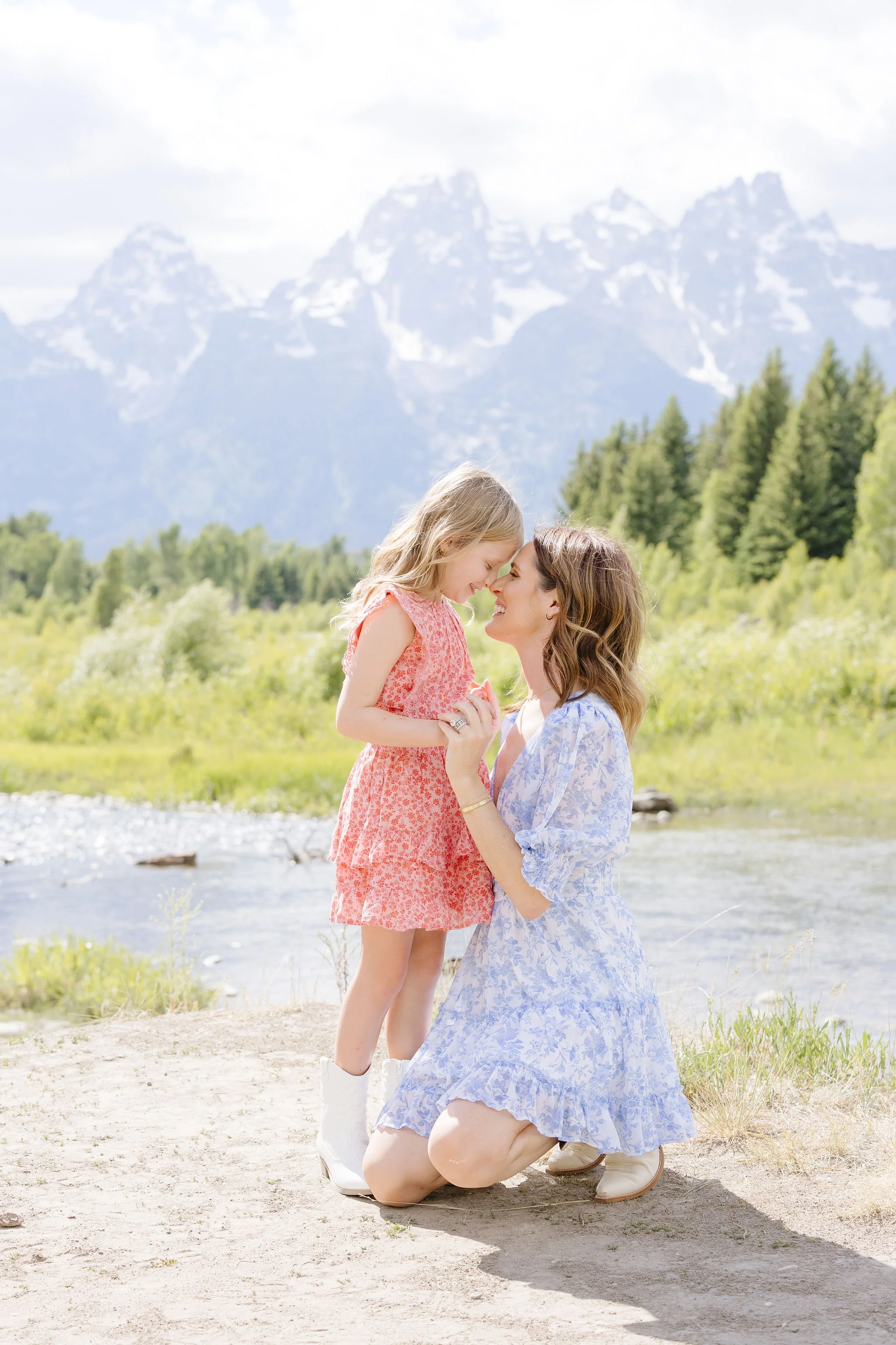  Mom crouches down to hug young daughter, proving family photo poses don’t have to be rigid. 