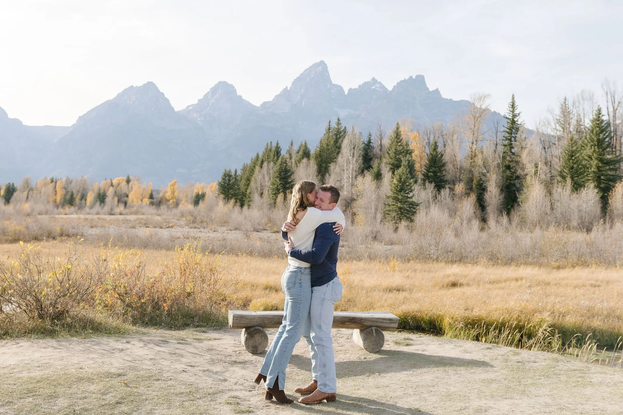 Man and woman hug after just getting engaged in the Tetons.