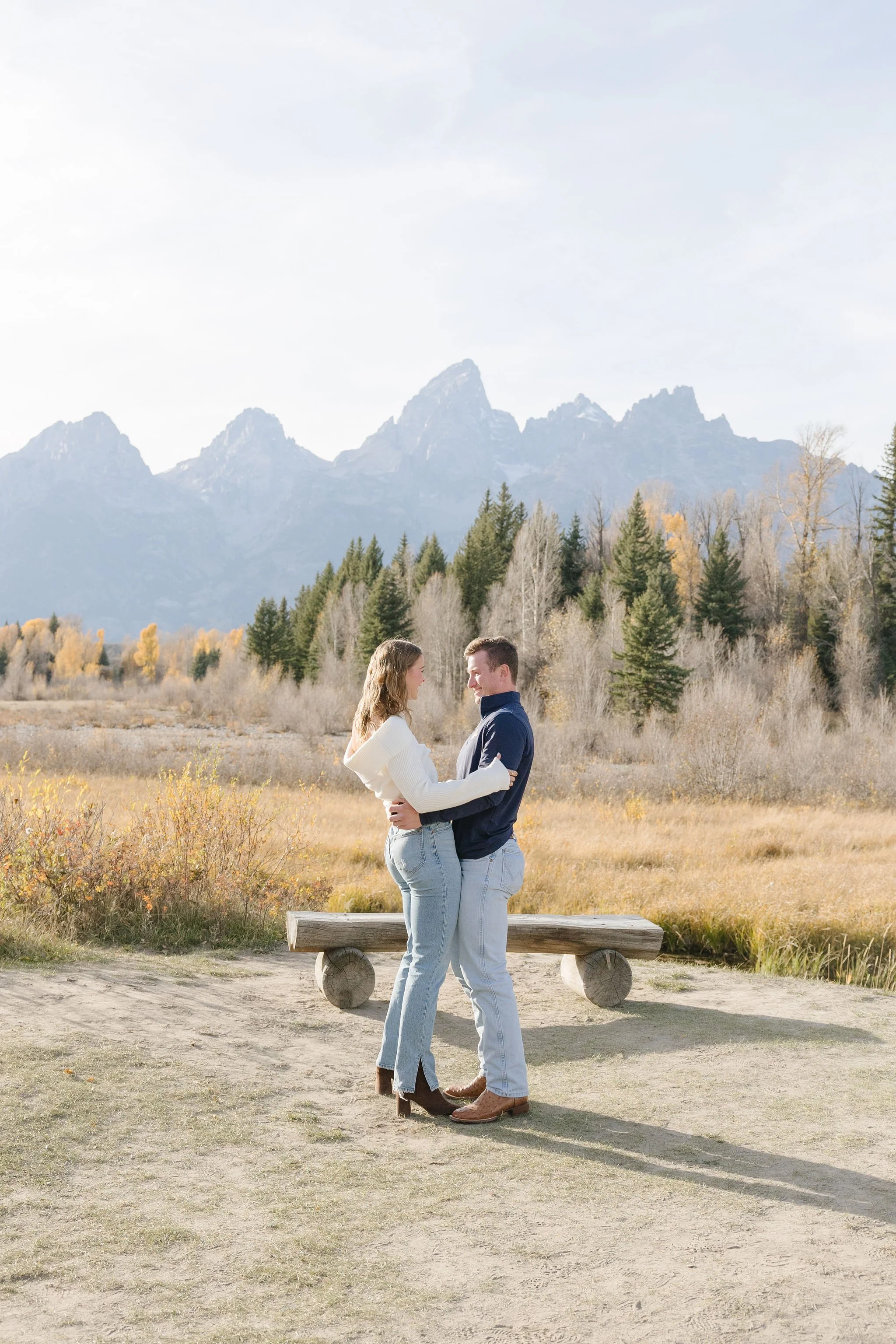   Couple stand together with the Teton mountain range behind them, so happy after thoughtful fall date planning in Jackson Hole. 