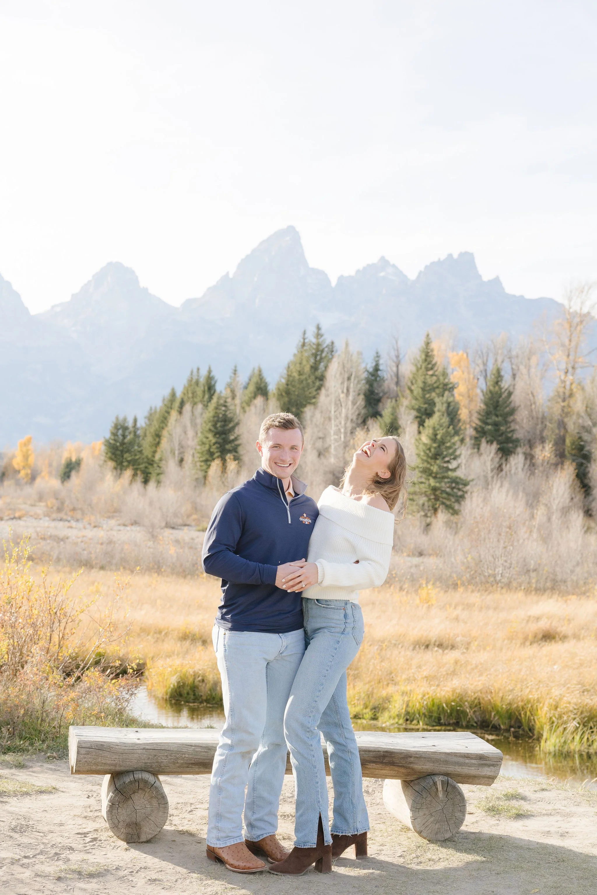  Couple stand together with the Teton mountain range behind them, so happy after thoughtful fall date planning in Jackson Hole. 