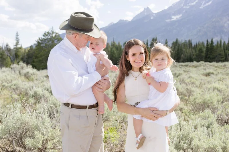  Grandfather holds young grandson with his daughter holding her other son. 